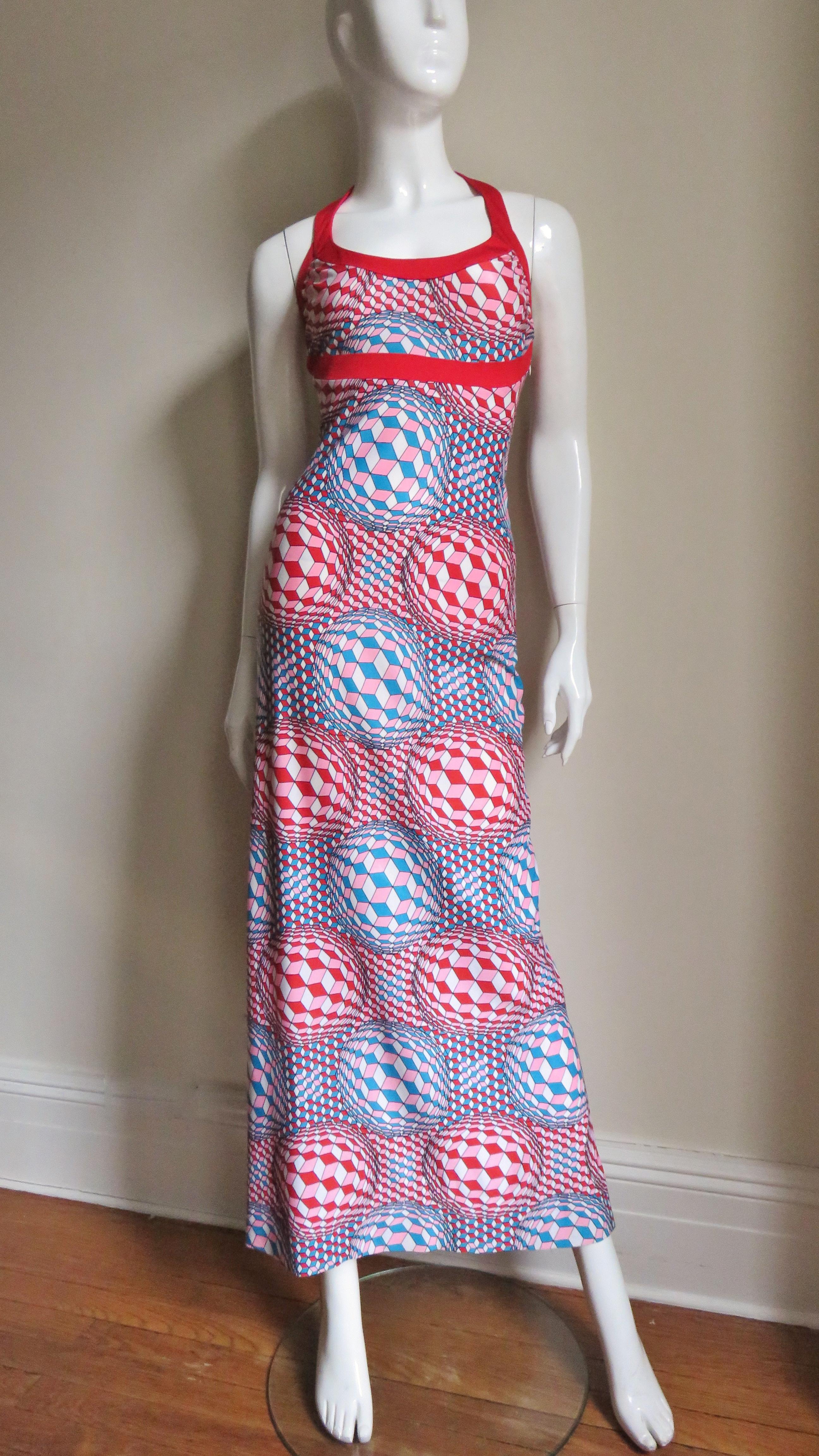 A great jersey halter dress in a turquoise, red, pink and white optical illusion print from Robert Morton..  It is semi fitted with a halter neck and a band of red around the neckline and under the bust. It comes with a matching open jacket with