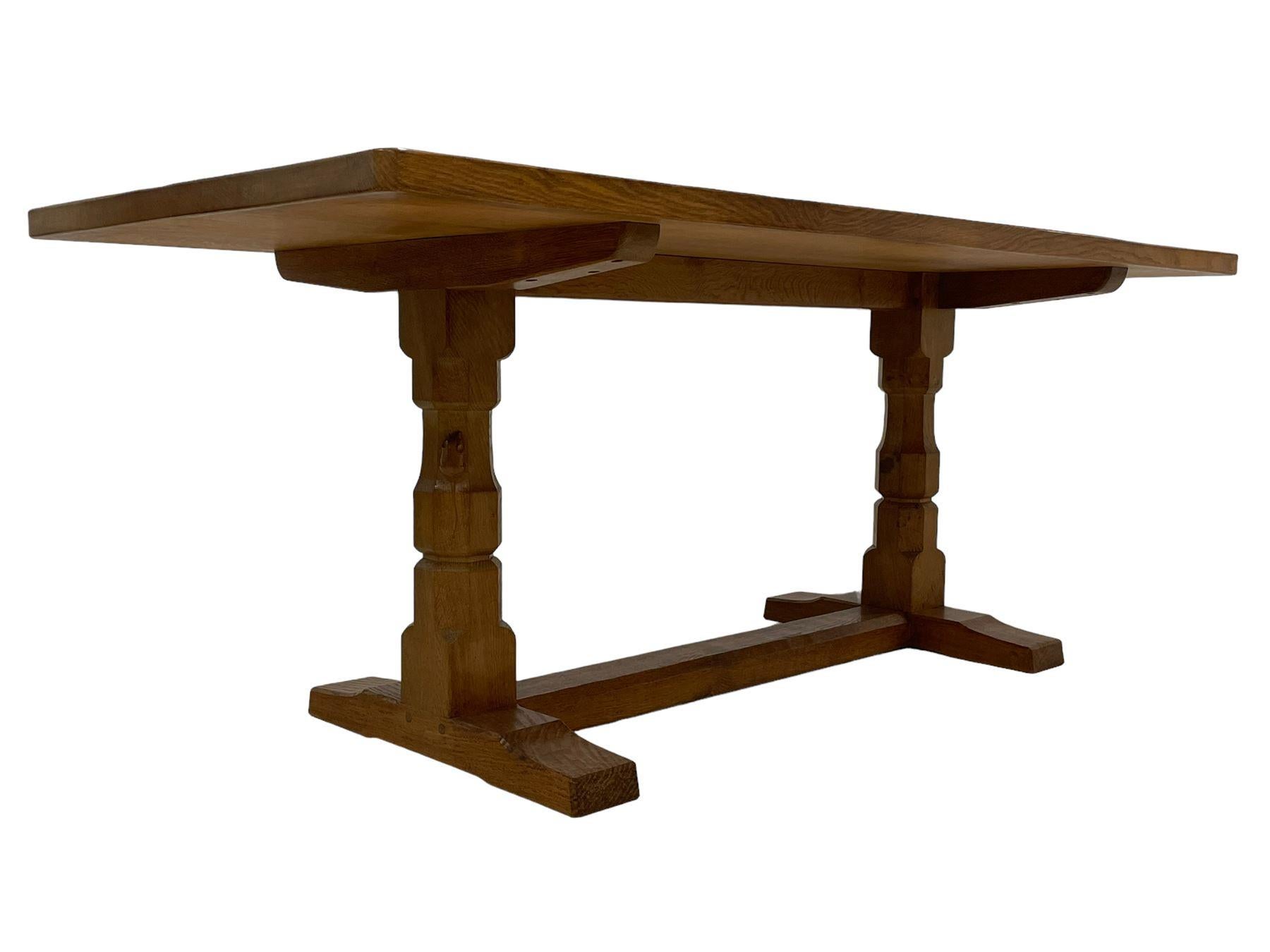  A beautiful set of Mouseman furniture – an adzed oak 6ft refectory table, with rectangular planked top raised on twin octagonal end supports on sledge feet united by a floor stretcher carved with fat mouse signature, and accompanied with six oak