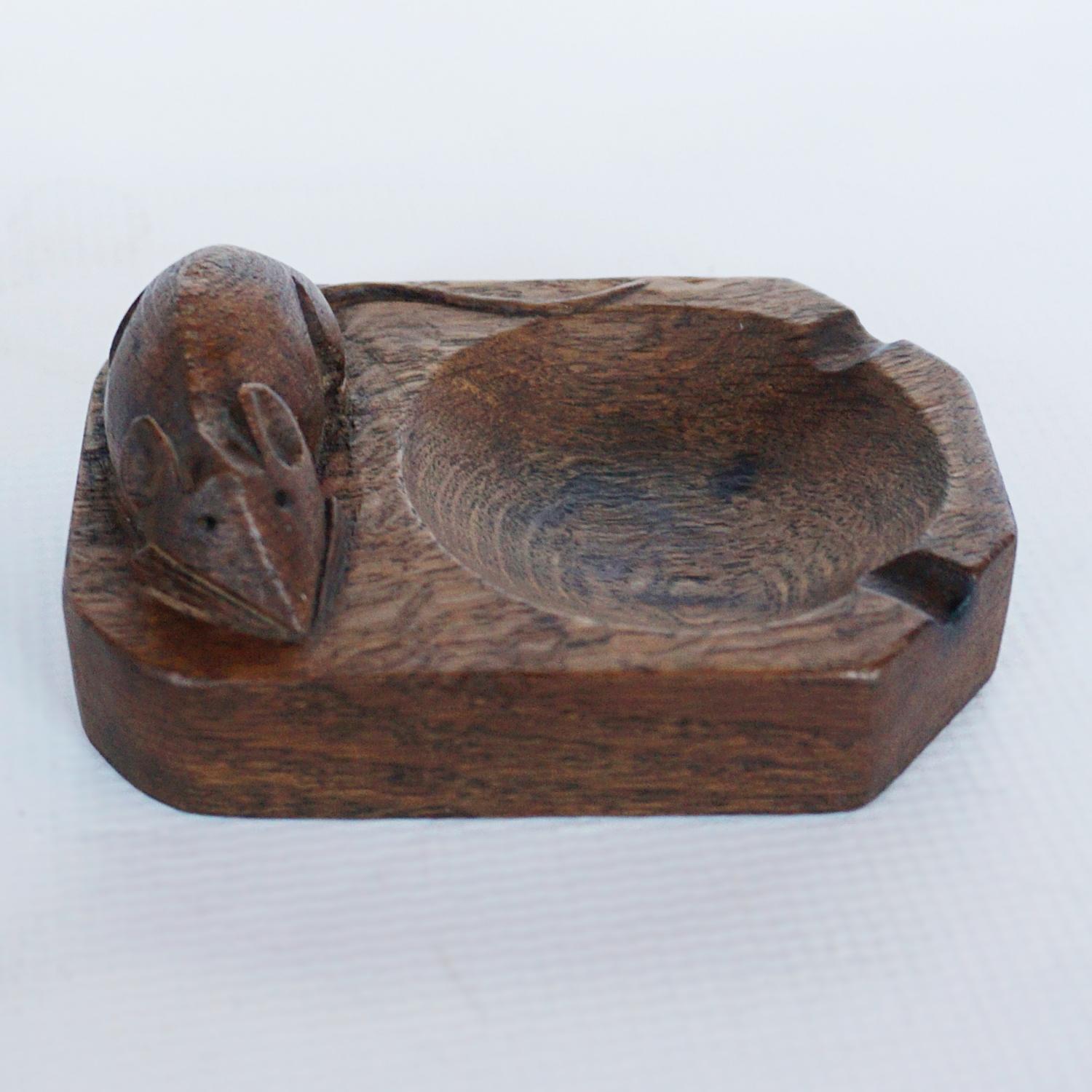 A carved wood ashtray by Robert 'Mouseman' Thompson. Excellent detail to mouse and tail.