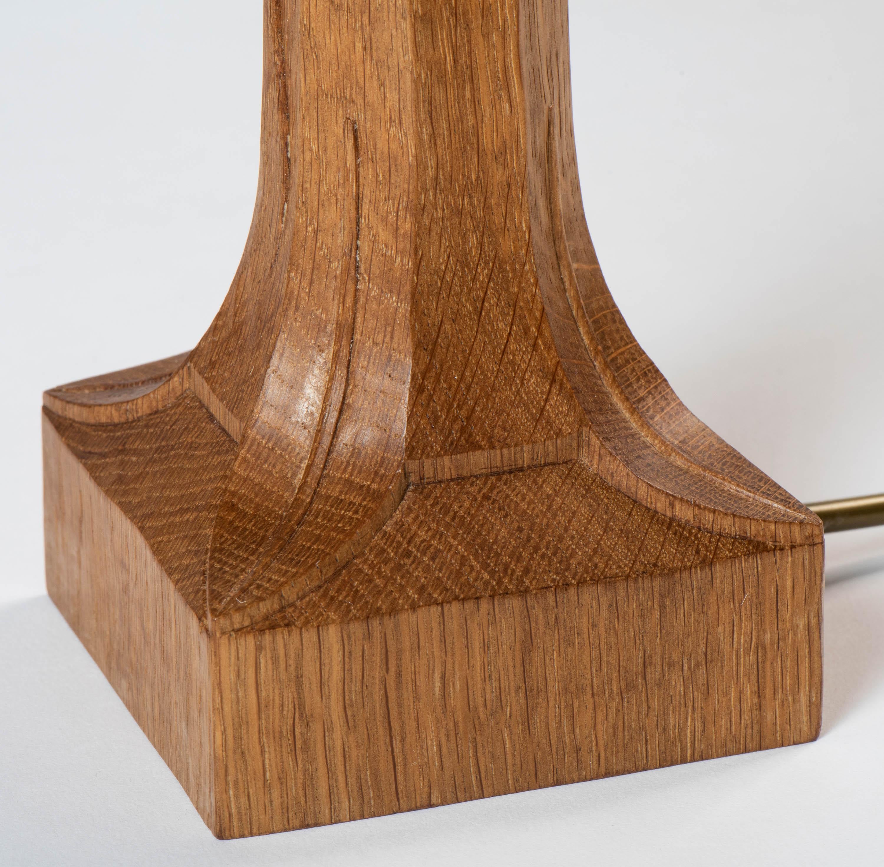 A Robert “Mouseman” Thompson table lamp.
Oak
Octagonal column on square base,
Carved mouse.
English, circa 1970
Parchment shade.
Measures: 26.5 cm high x 23 cm wide x 23 cm deep.
 