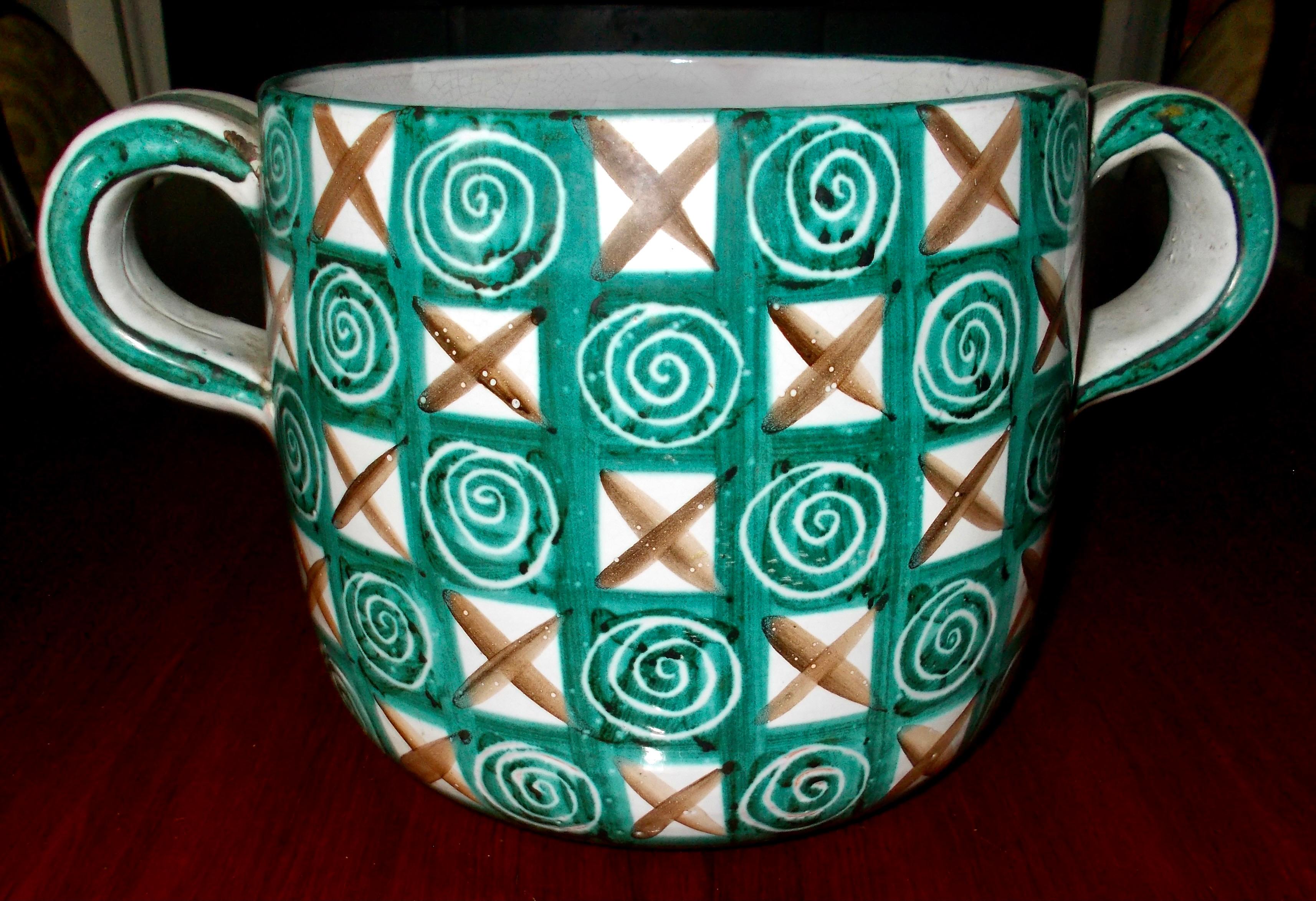Important grand pot avec poignées décoré à la main de peinture verte et brune dans un style typique et unique de Picault de carrés, de spirales et de x's. 16,25 cm de haut x 20 cm de diamètre. 32 cm de poignée à poignée.