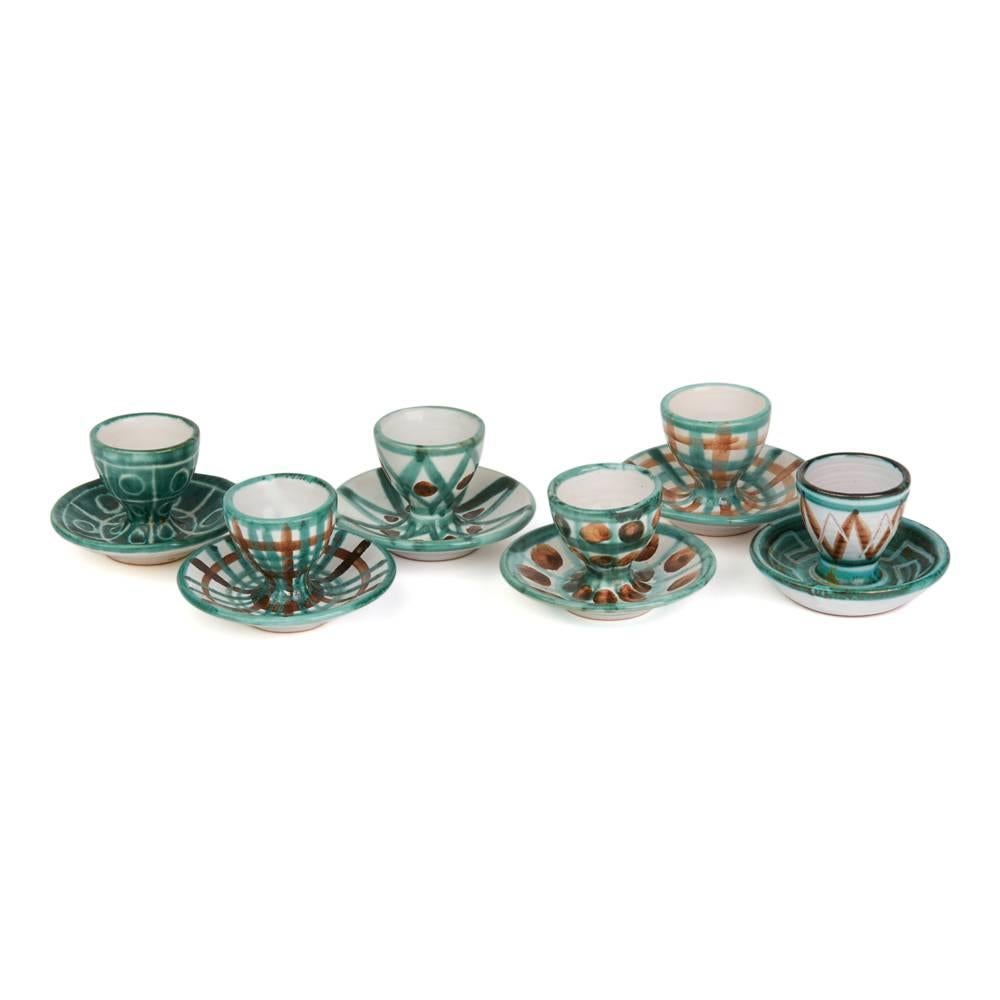 A rare and important stunning French art pottery set six egg cups on integral rounded stands by Robert Picault and made in Vallauris in the South of France. Working closely to Picasso each piece is hand decorated with green, brown and incised