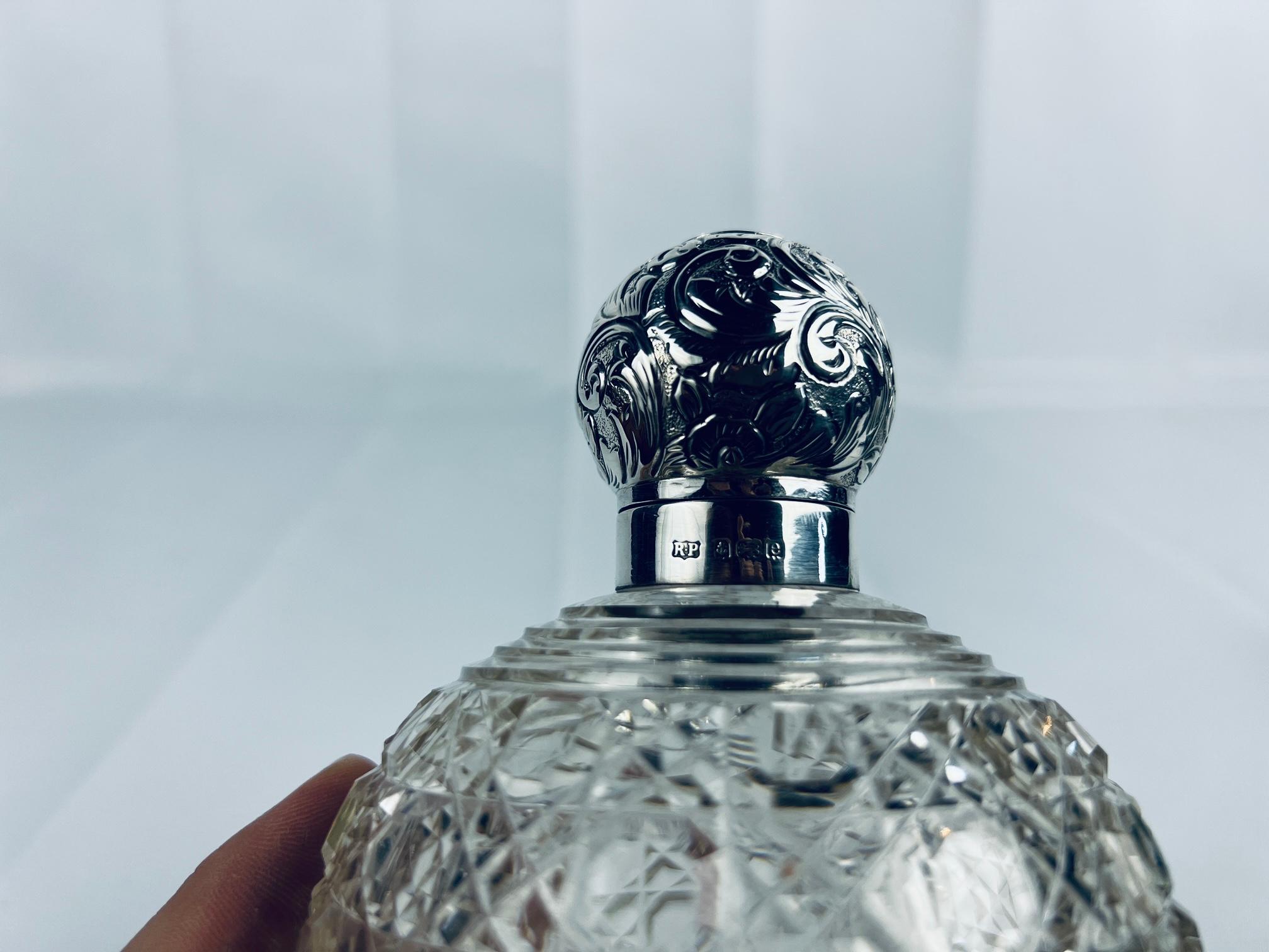 Este exquisito frasco de perfume de la época eduardiana, fabricado por Robert Pringle & Sons de Birmingham, es una mezcla perfecta de elegancia y fina artesanía. El cuerpo está hecho de cristal finamente tallado, con intrincados dibujos que realzan