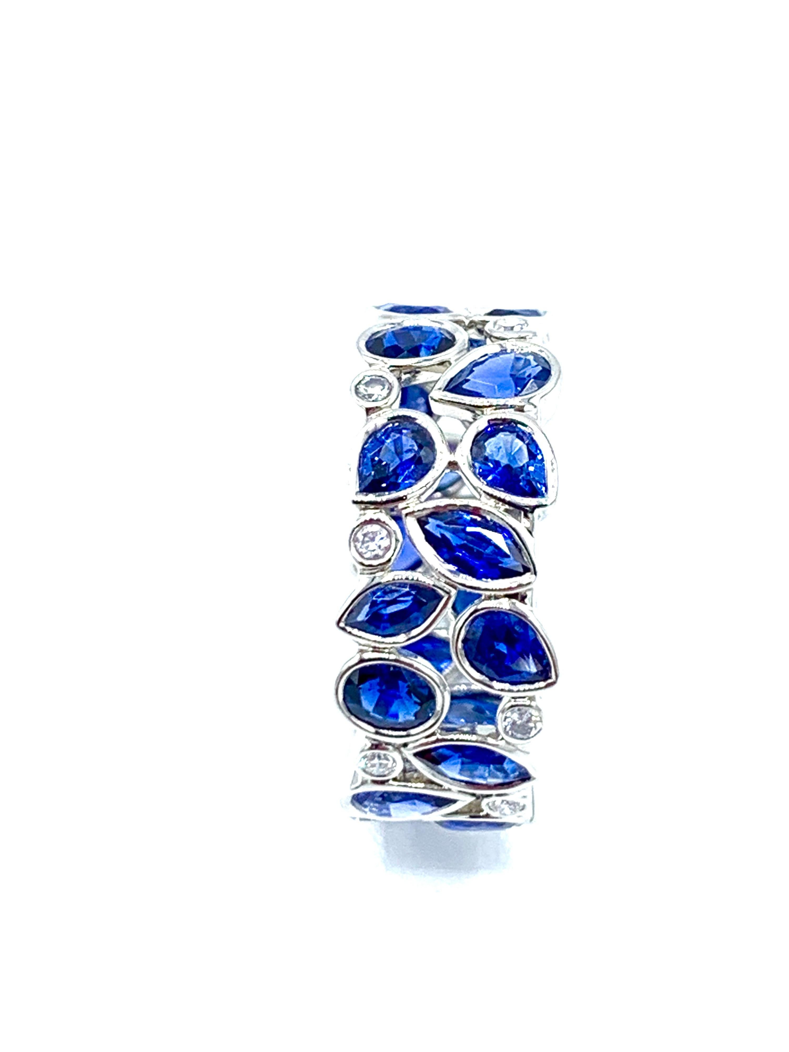 An absolutely amazing  Robert Procop De La Vie Collection band ring! The ring handcrafted in platinum with bright blue Sapphires and scintillating Diamonds. There are 26 various shaped blue Sapphires totaling 4.27 carats, and 14 round brilliant