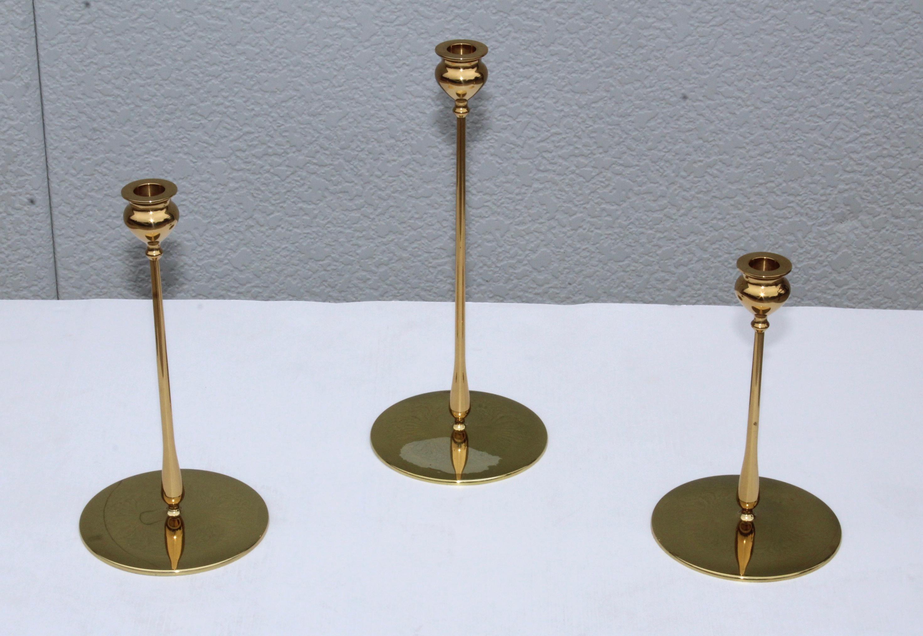 Stunning set of 3 art & crafts Delta candlesticks after Robert Jarvie made by Virginia Metalcrafters in 1998. in original condition, with minor wear and patina to the brass, there is some wear to the finish of one of them.

Medium candlesticks