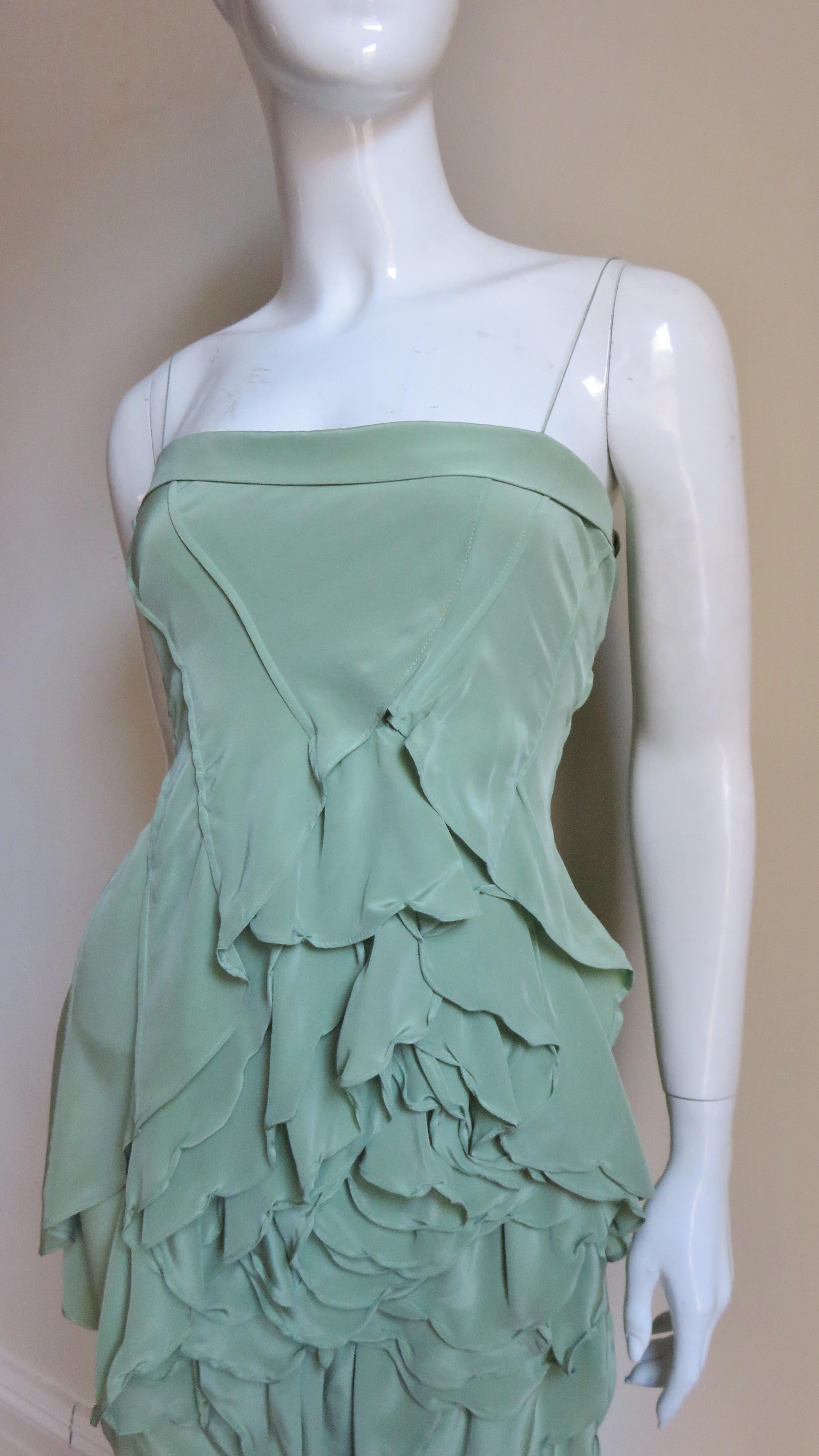 A fabulous mint green silk dress by Robert Rodriguez. It has spaghetti straps and lots of diagonal seaming leading to a large petal flower comprising most of the skirt front.  It has a center back matching zipper.
Fits sizes Small, Extra Small,