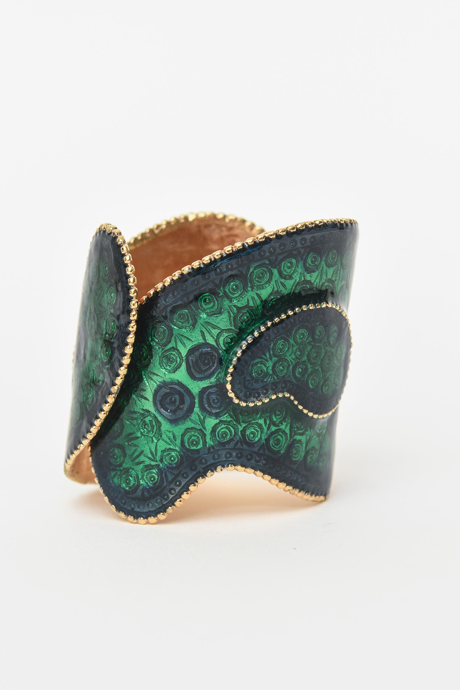This amazing and rare stunning emerald green with blue hinged 60's cuff bracelet is by Robert and signed. His enamel work on this is very fine. This form of enameling is called guilloche which involves engraving the design onto metal and applying