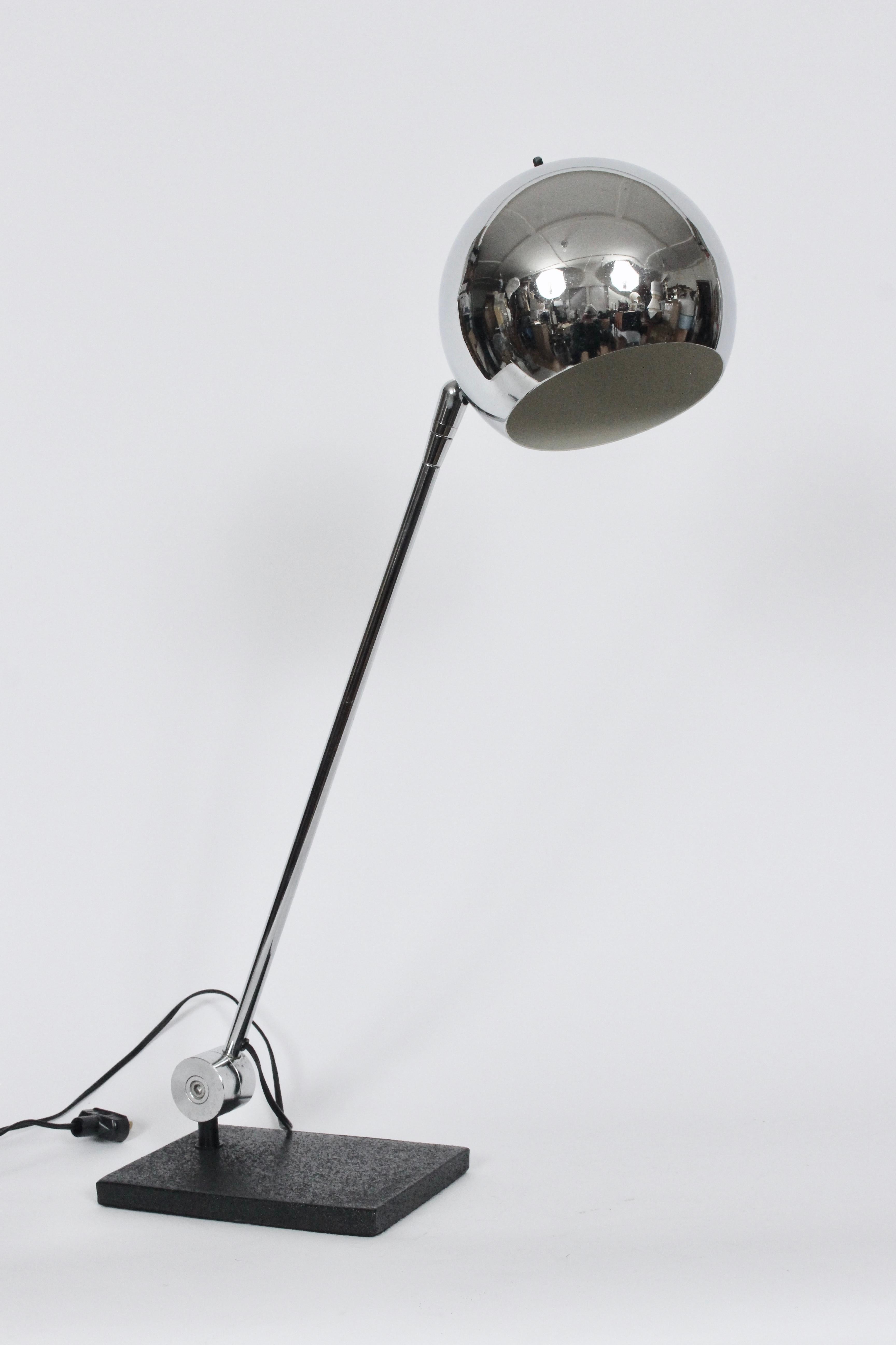 Modern Robert Sonneman adjustable chrome globe desk lamp, Circa 1970. Featuring a heavy Black enameled rectangular base (5.5 x 8) with reflective, vented, articulating (7D) chrome ball shade and off white enameled interior. Standard socket. Turn