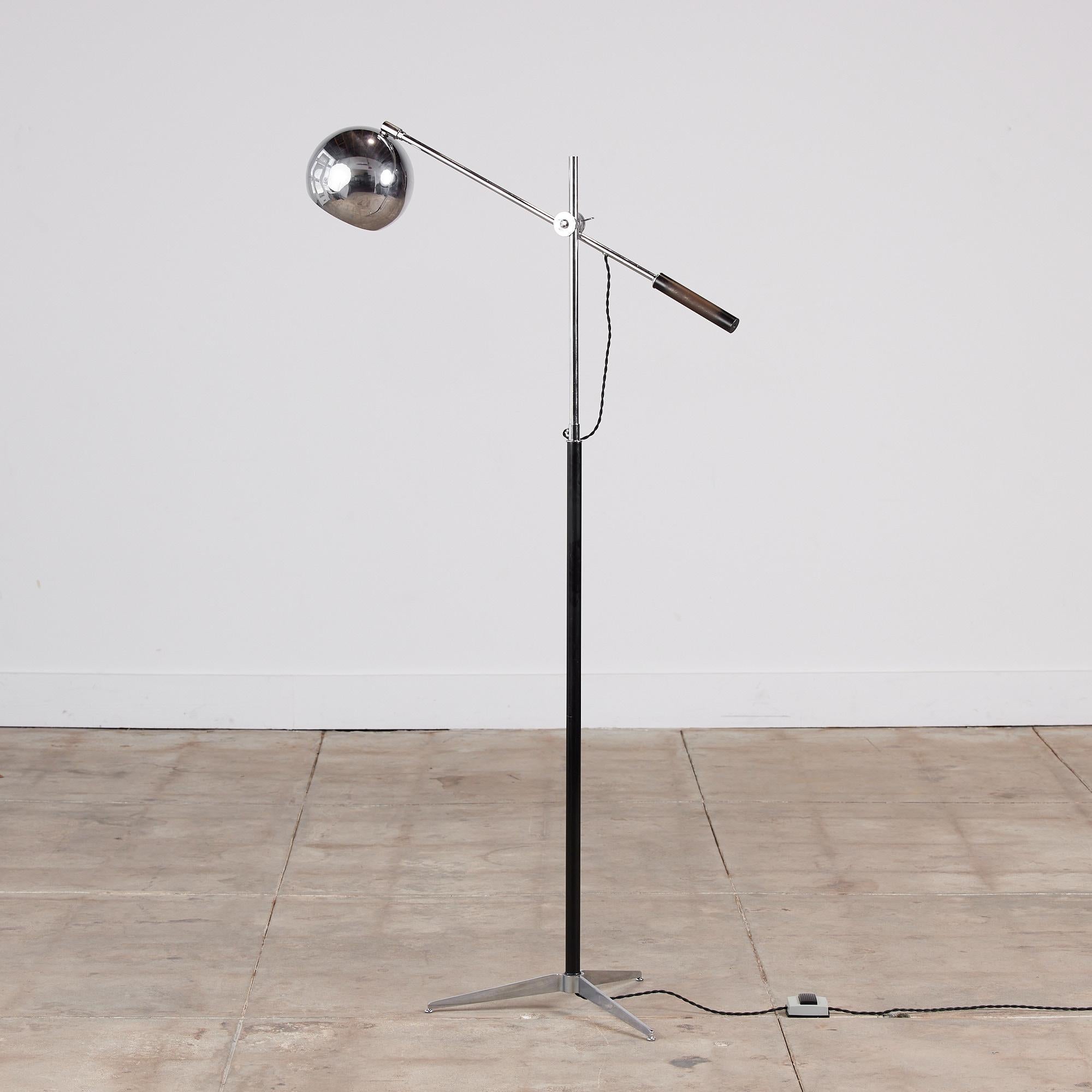Robert Sonneman eyeball floor lamp c.1960s, USA. The lamp features a chrome sphere shade on a pivoting arm that can be adjusted to multiple vertical heights with cylindrical black handle. The stem of the lamp is a narrow chrome and black cylindrical