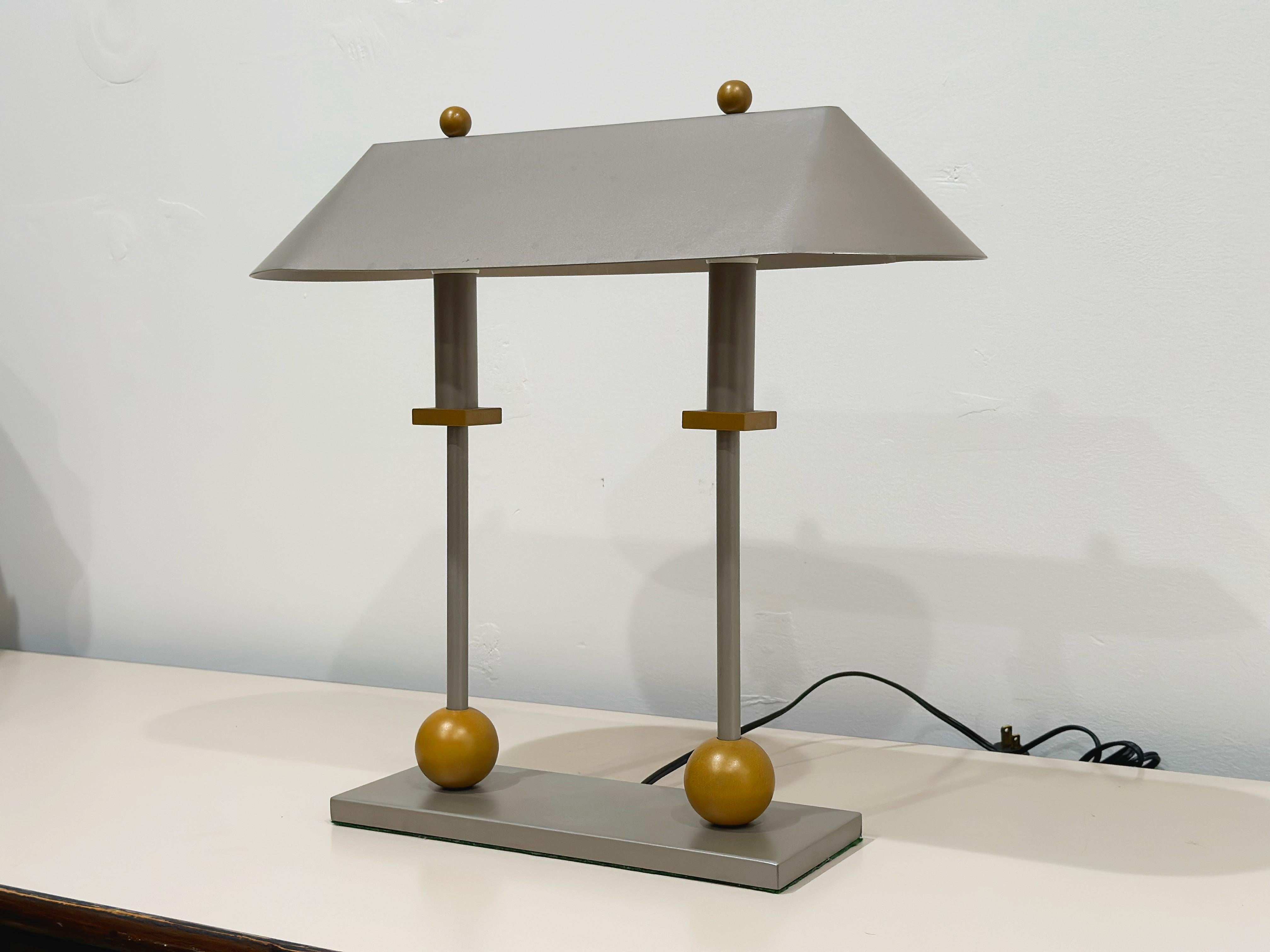 Rare bankers lamp form, Post Modern - Memphis Milano style, desk lamp designed by Robert Sonneman for George Kovacs circa 1980s. The base is of two tone metal, silver gray, with mat finish brass decorative trim elements. The lamp is in excellent