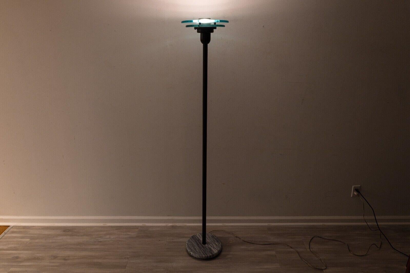 A Robert Sonneman for George Kovacs post modern metal and glass torch floor lamp. A lovely post modern lamp with a gorgeous design. This torch lamp features a black metal construction with a round marble base, and blue glass halo accents at the top.