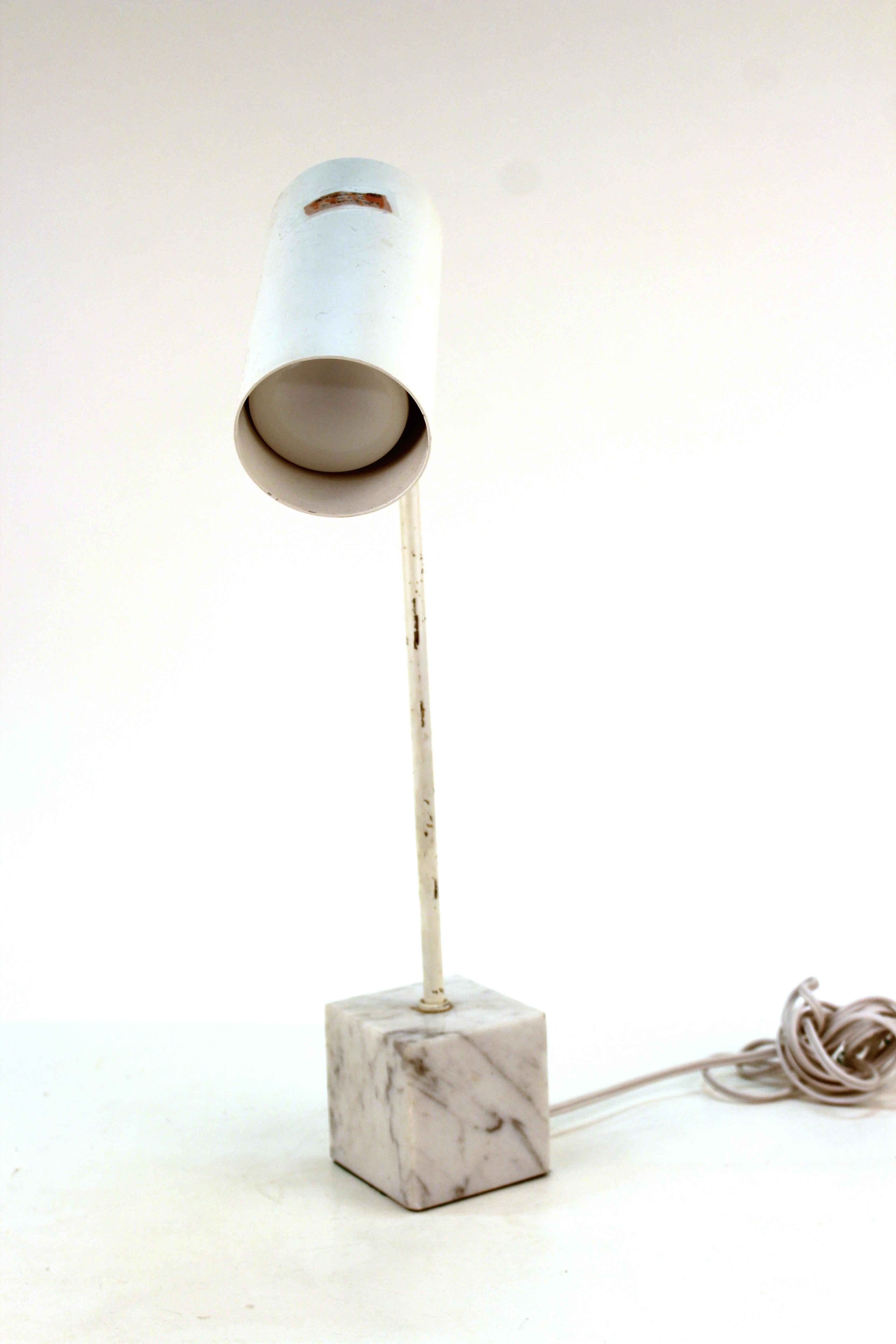 Robert Sonneman for Kovacs Mid-Century Modern cream painted table lamp with a movable can, atop a white and grey marble bloc. The piece has some scratches to the metal finish but is in overall great vintage condition.