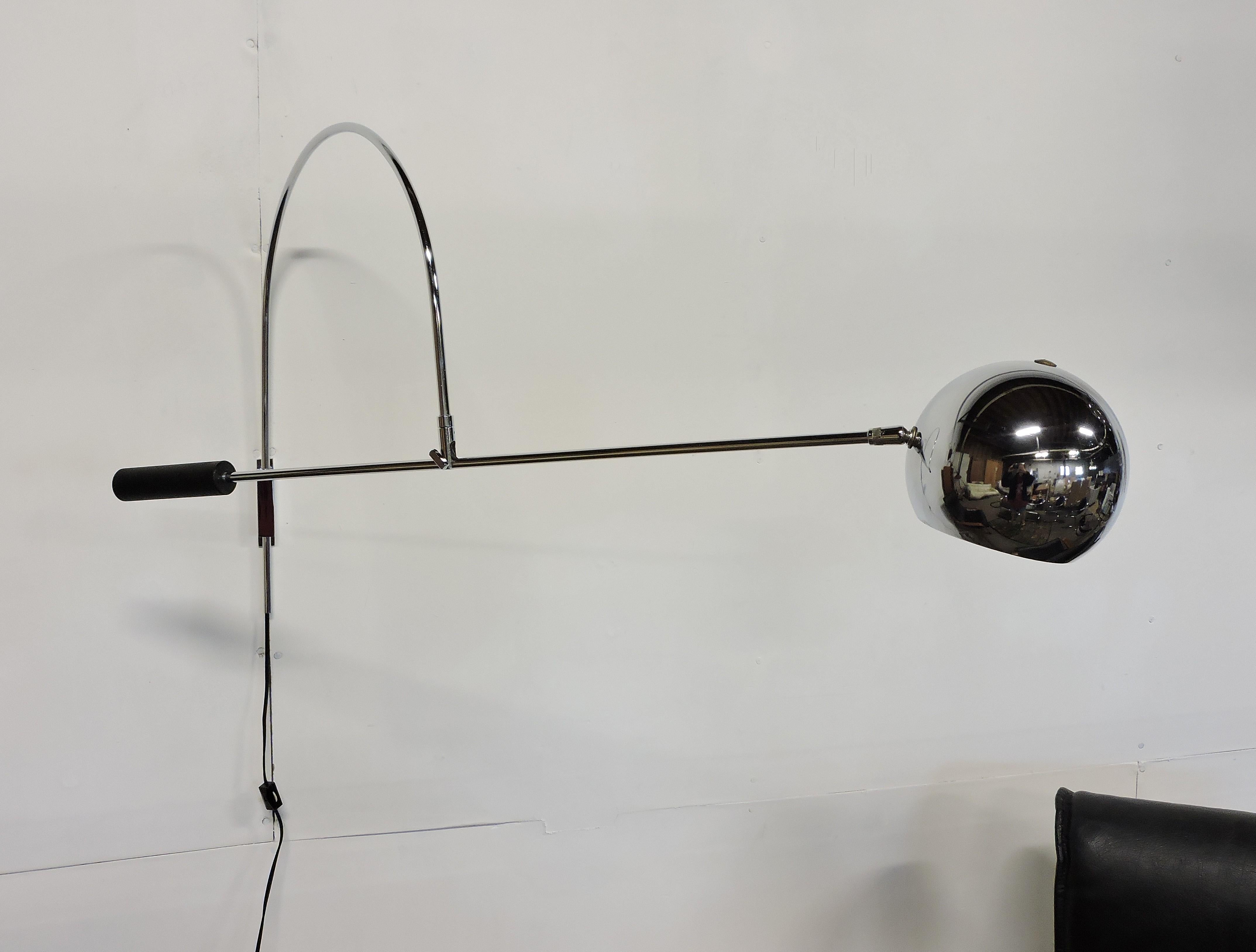 Original orbiter chrome wall lamp by Robert Sonneman. This lamp has a wall-mounted bracket, and can be adjusted by swinging from side-to-side and also by moving the arm up and down. There is an inline on/off switch.