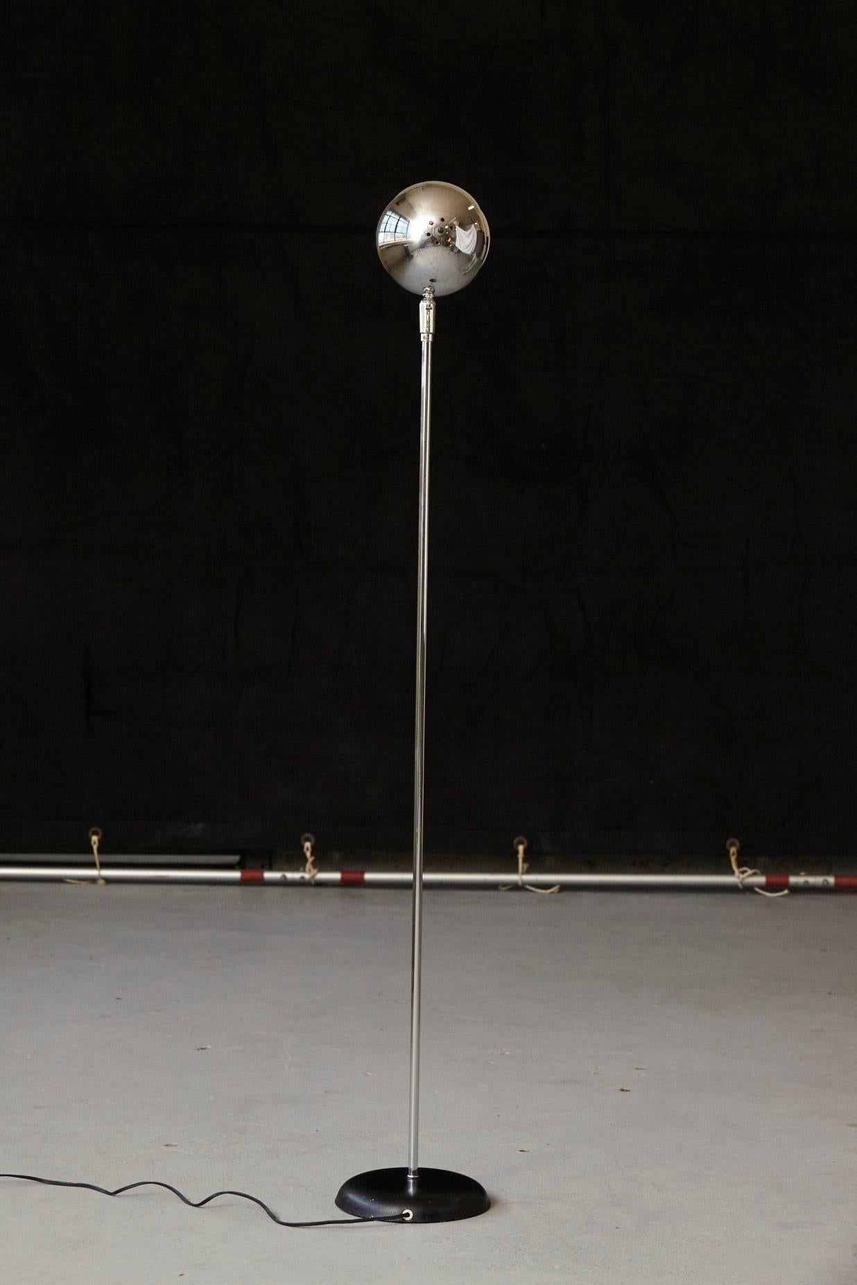 Minimalist chrome eyeball floor lamp in the style of Robert Sonneman with black base. The chrome head is adjustable.