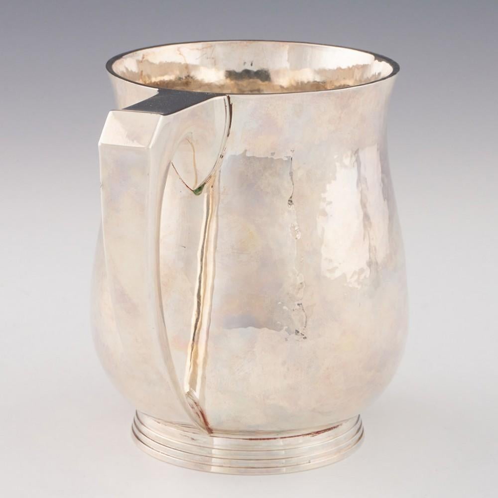 Heading : RE Stone silver pint tankard
Date : Hallmarked in London in 1953 for RE Stone - also has Jubilee mark 
Period : Elizabeth II
Origin : London, England
Decoration : Baluster form with hammered / planished finish and angular handle. Base