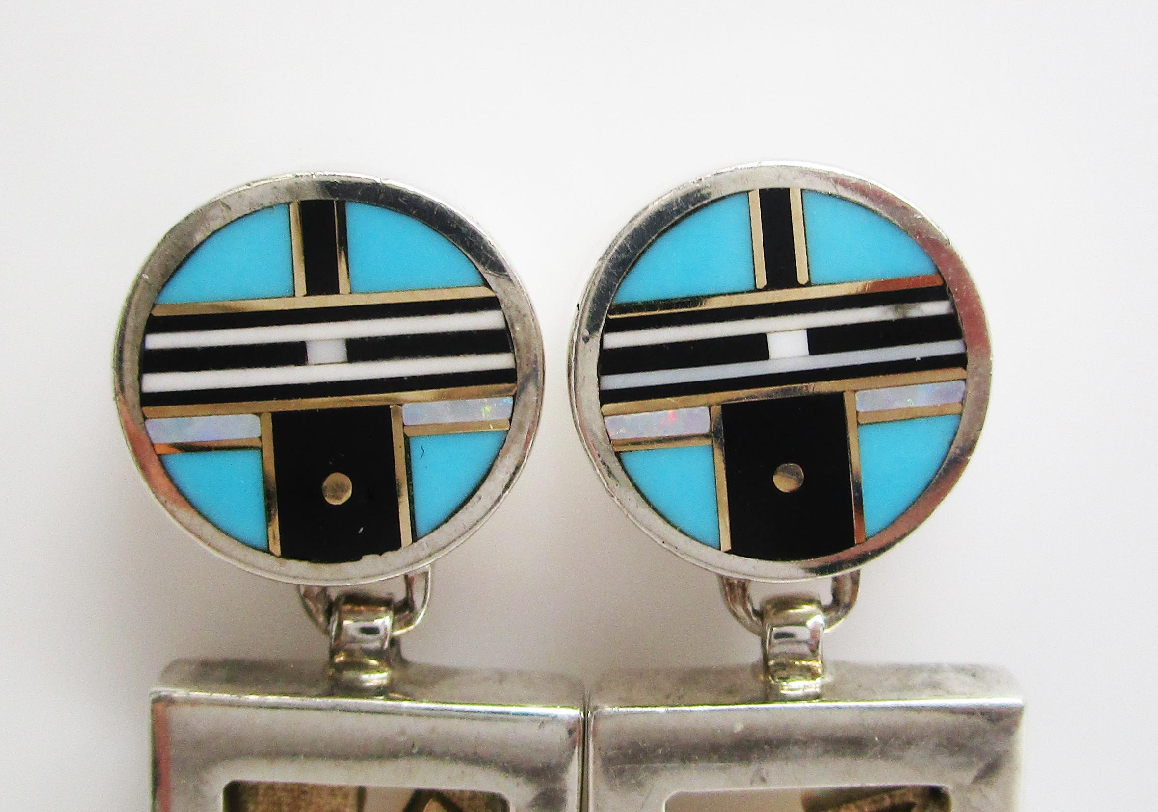 This is a great pair of Navajo earrings by Robert Taylor II in sterling silver and 14k yellow gold. The dangle earrings have a two-part articulated layout that creates fantastic movement! The upper portion of the earring features a geometric design