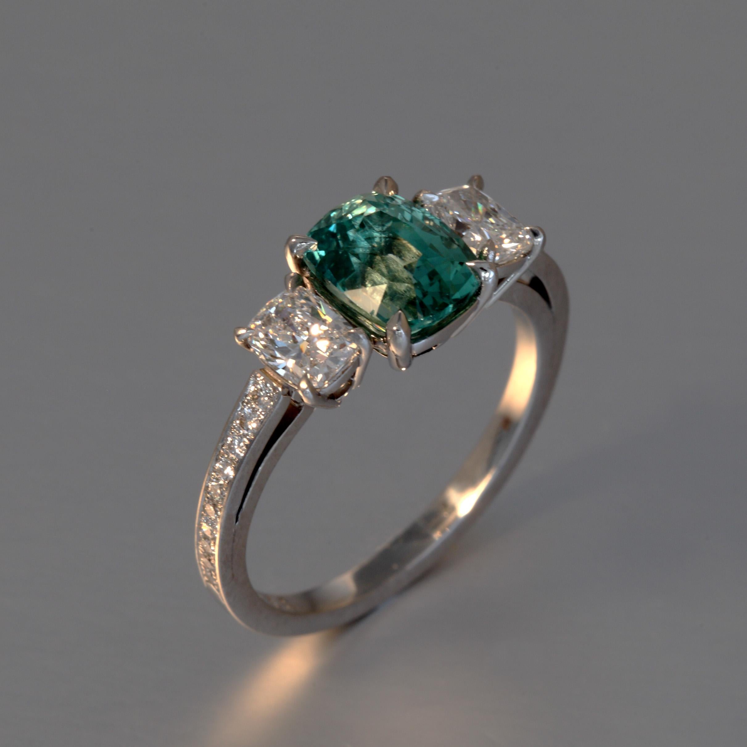 A fine blueish green Vanadium Chrysoberyl of 1.85 carat F,G vvs and two cushion cut diamonds with a total of 0.63 carat are set with 0.10 carat of small round diamonds F,G vvs in a platinum ring. This one of a kind piece is designed and hand made in