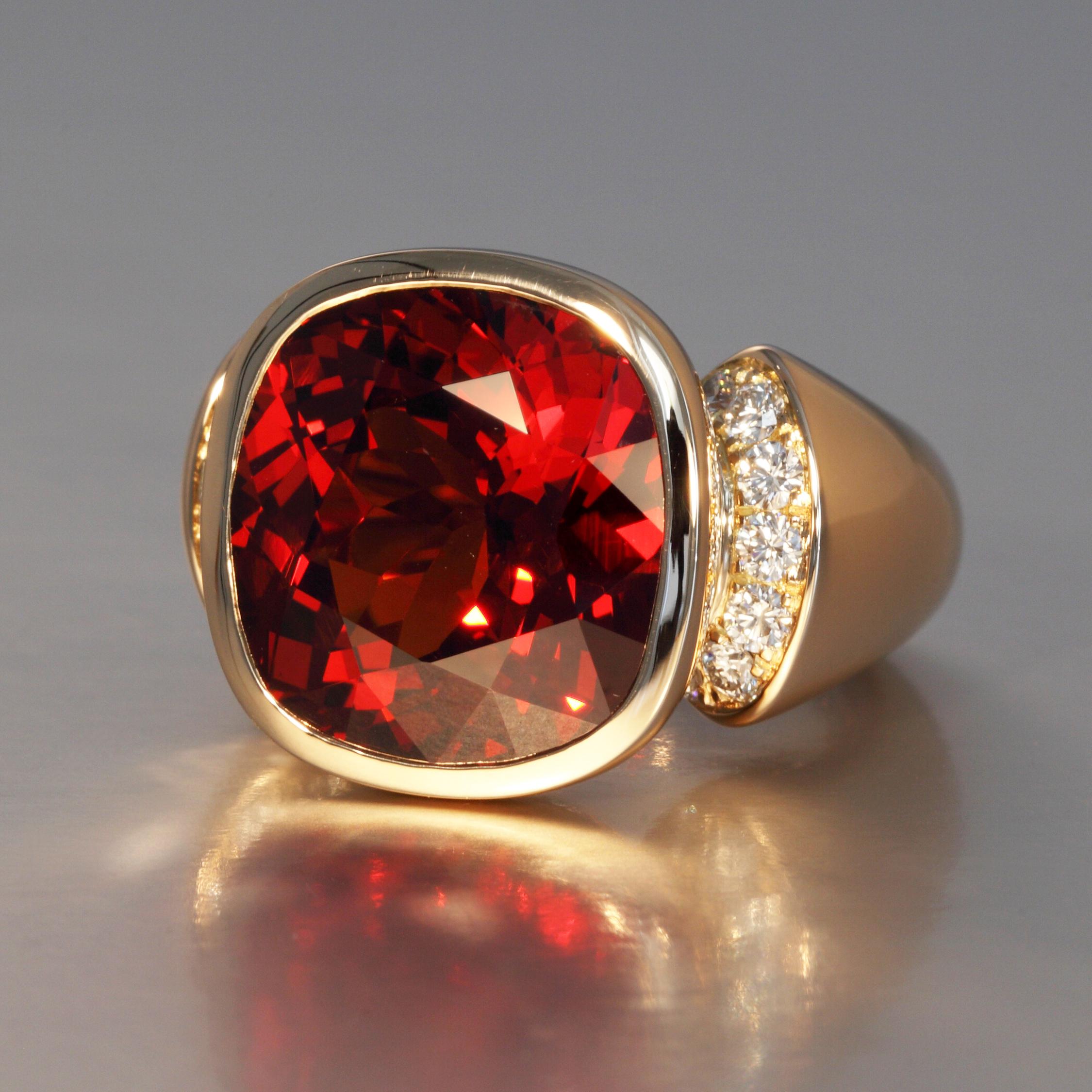 This vibrant fine 24.22 carat cushion natural red spessartite garnet is mounted with fourteen diamonds F,G vvs 0.60 carat in a rose gold ring. An inner spring moves easily over the knuckle and holds the ring in place. This one of a kind piece is