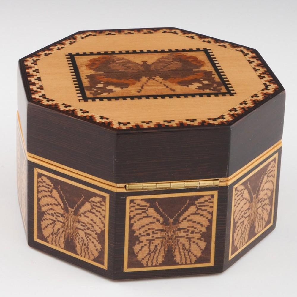 Heading : Robert Vorley octagonal Tunbridge ware jewellery box
Date : 2022
Period : Elizabeth II
Origin : Essex
Decoration : Central mosaic of a Red Admiral butterfly within keylines. Geometric boreder. Side panels each ecorated with a black veined