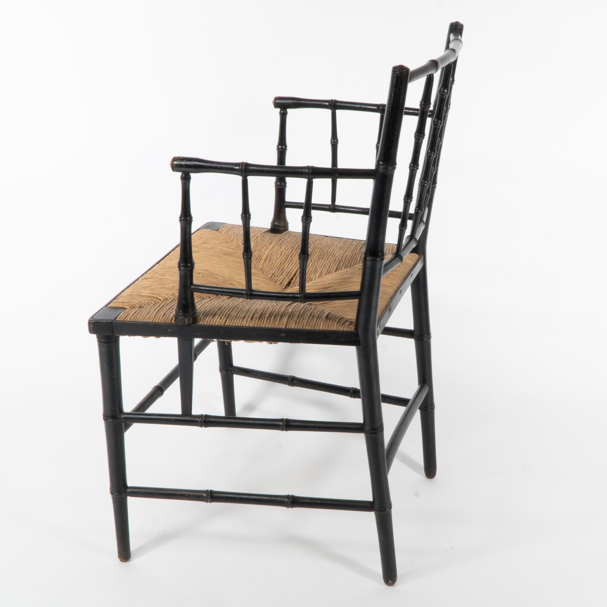 Ebonized Robert W Edis, An Aesthetic Movement rush seat armchair in the bamboo style For Sale