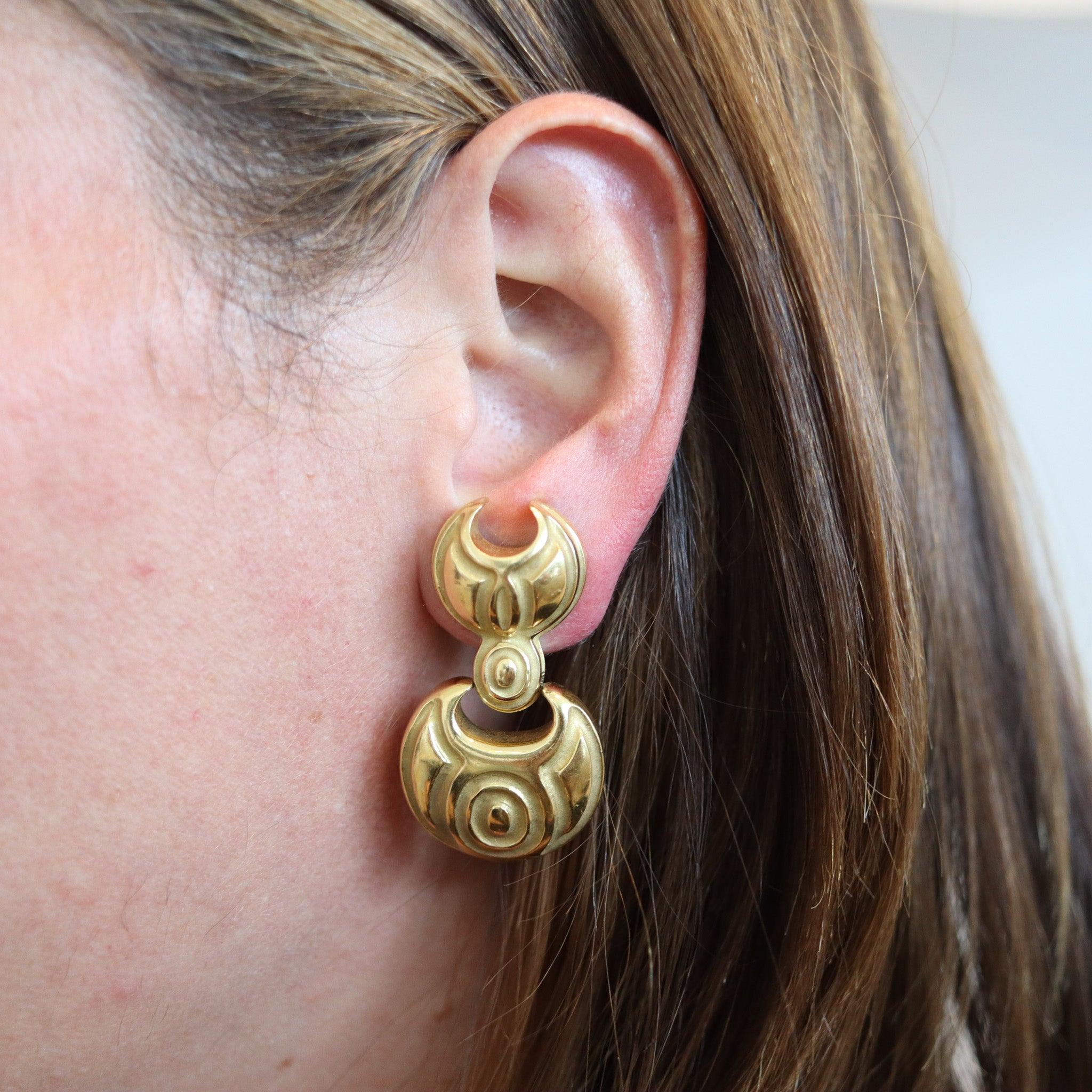 Door knockers earrings designed by Robert Wander.

Beautiful pair of doors knockers earrings, created at the jewelry atelier of Robert Wander, back in the 1970. This beautiful dangle drops pair has been crafted with bold geometric patterns in solid