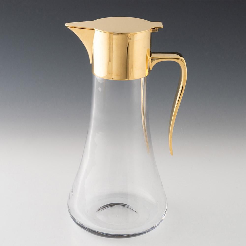 Heading : Robert Welch gilt silver and glass claret jug
Date :   Hallmarked in London in 1988 for Welch
Period : Elizabeth II
Origin : London, England
Colour : Clear with silver gilt cover and handle
Body : Tear drop form glass with angular silver