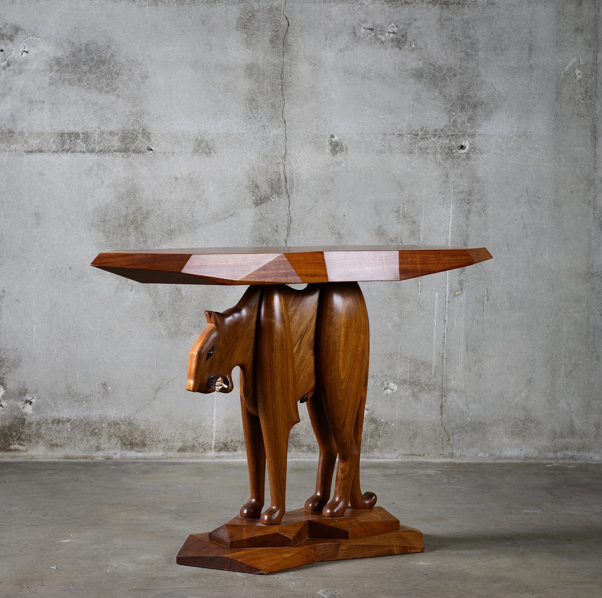 A walnut, rosewood, ebony and metal table by Robert Whitley (American, b. 1925), top supported by leopard figure.