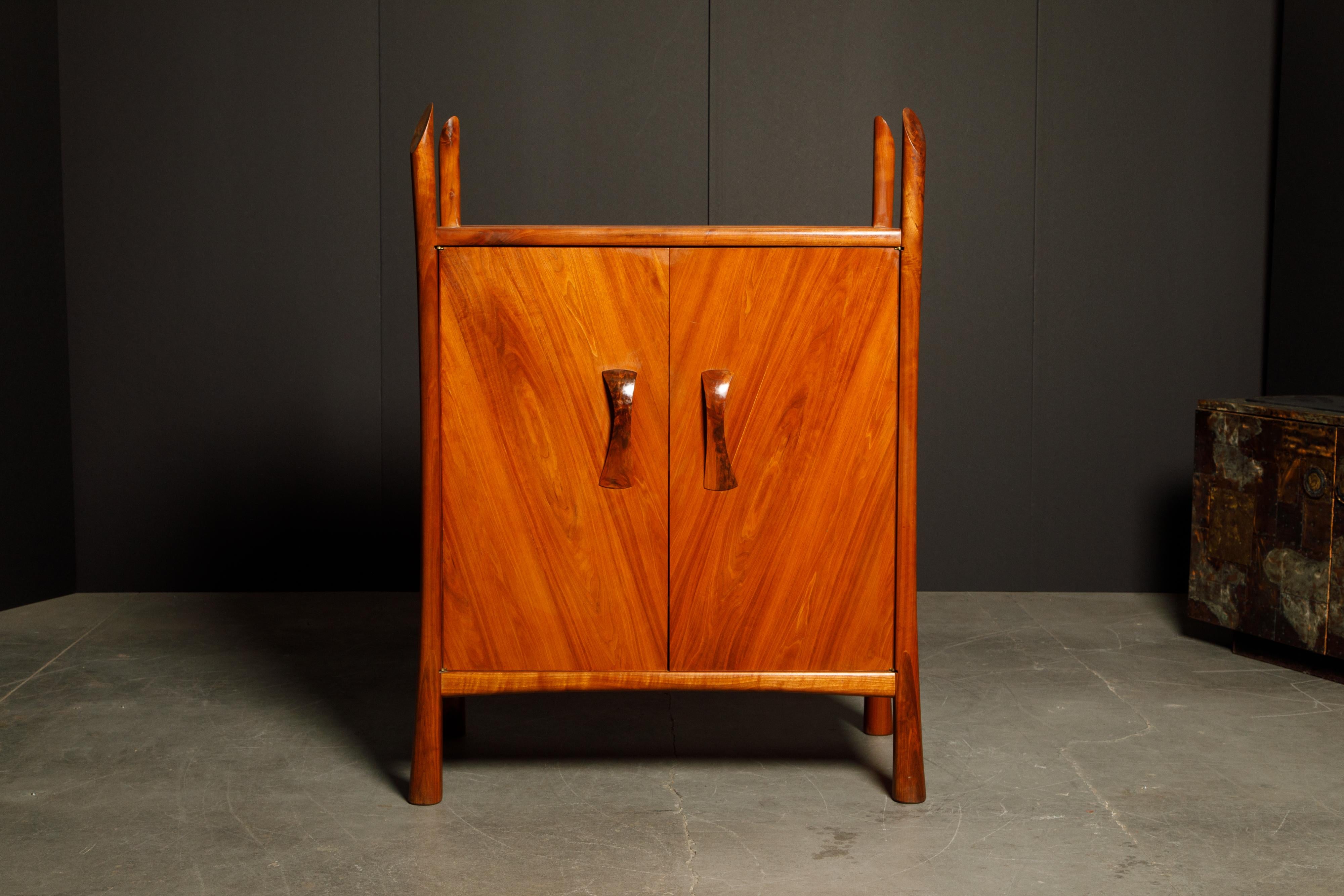 An incredibly beautiful studio case piece by New Hope craftsman Robert Whitley featuring solid sculptural walnut legs which extend upwards above the top of the cabinet giving this statement piece a bit of a sinister look, highly figured walnut