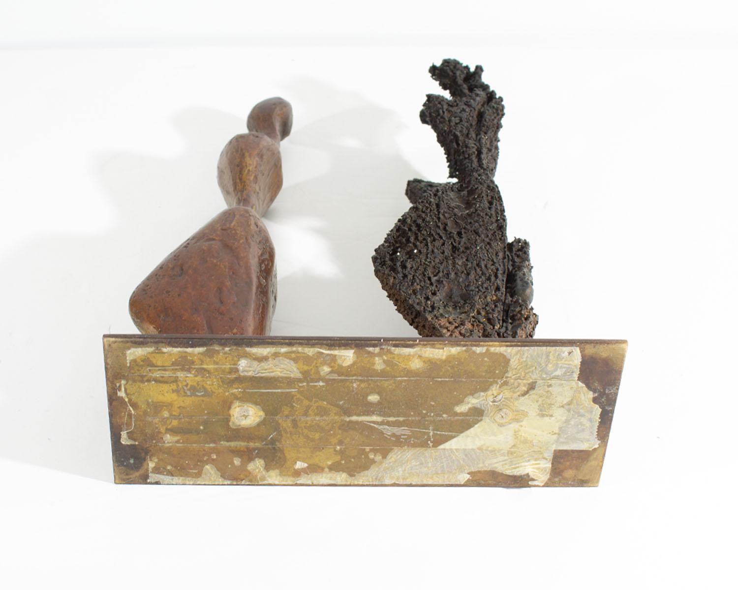 A limited edition bronze sculpture titled ﻿Emerging ﻿by the American artist Robert X. Holmes (born 1927). A bronze figure stands in front of a darker figure positioned identically with the latter figure appearing to be the shadow of the leading