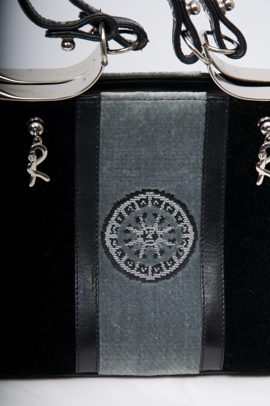 Roberta Di Camerino ha un'iconica borsa in velluto nero, con la sezione centrale verticale in velluto grigio davanti e dietro, la parte anteriore accentuata da un ricamo a forma di ruota; inoltre, il velluto grigio è separato dal nero da inserti in