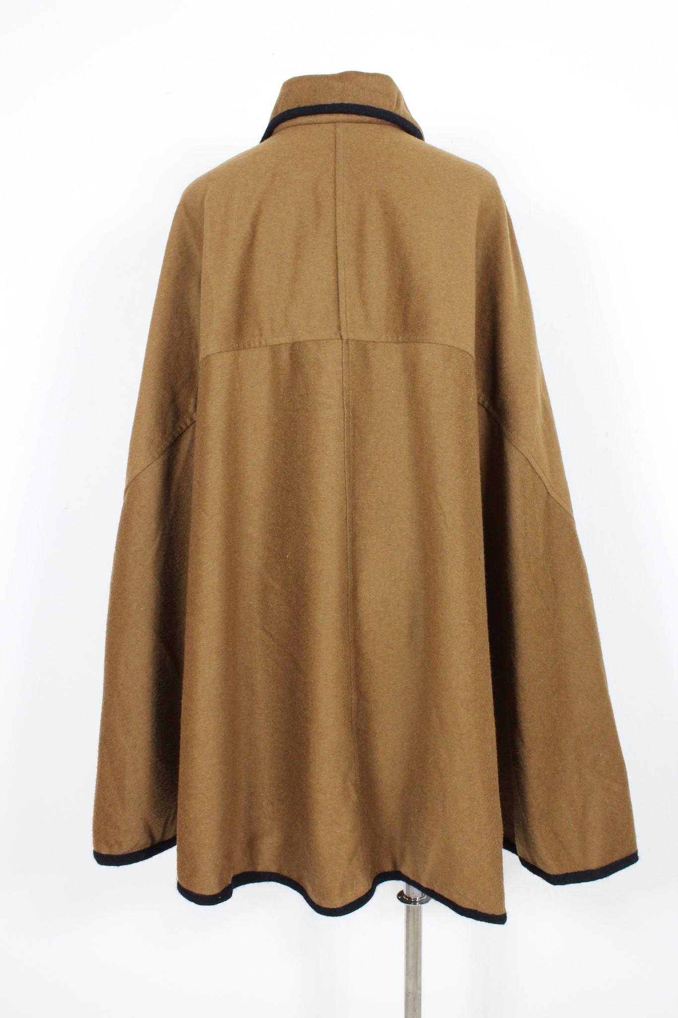Roberta di Camerino vintage 80s enveloping cape. Brown color with black edges, clip closure at the neck. Gold colored pin on the collar. Wool and cashmere fabric, internally lined. Made in Italy.

One size

Width: 100 cm
Length: 103 cm