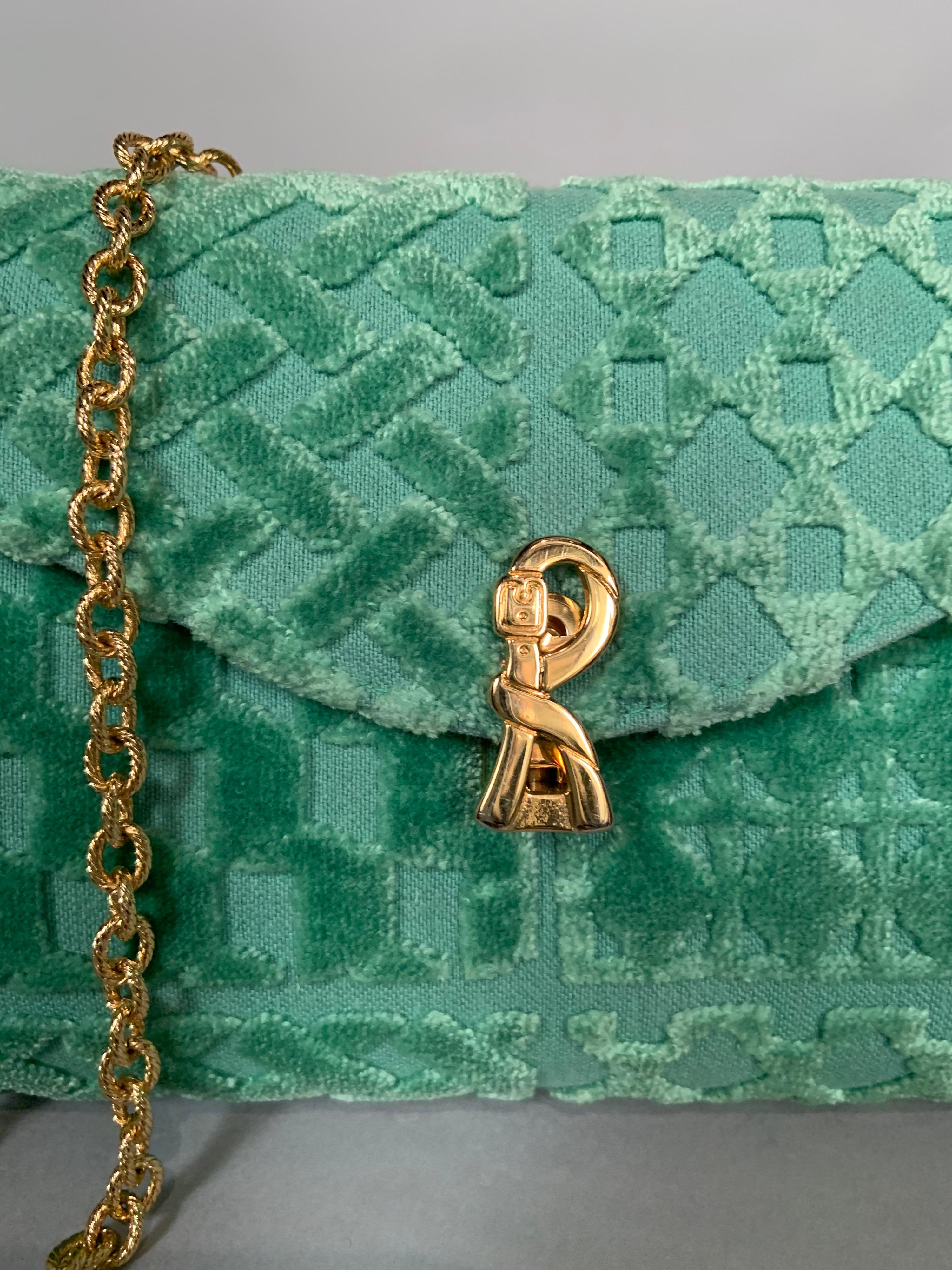 This Roberta di Camerino  bag is a great pop of color and it would work equally well with light or dark outfits. The clasp is the signature R belt logo in gold toned metal. The interior is pristine green silk faille. There is one large slip pocket