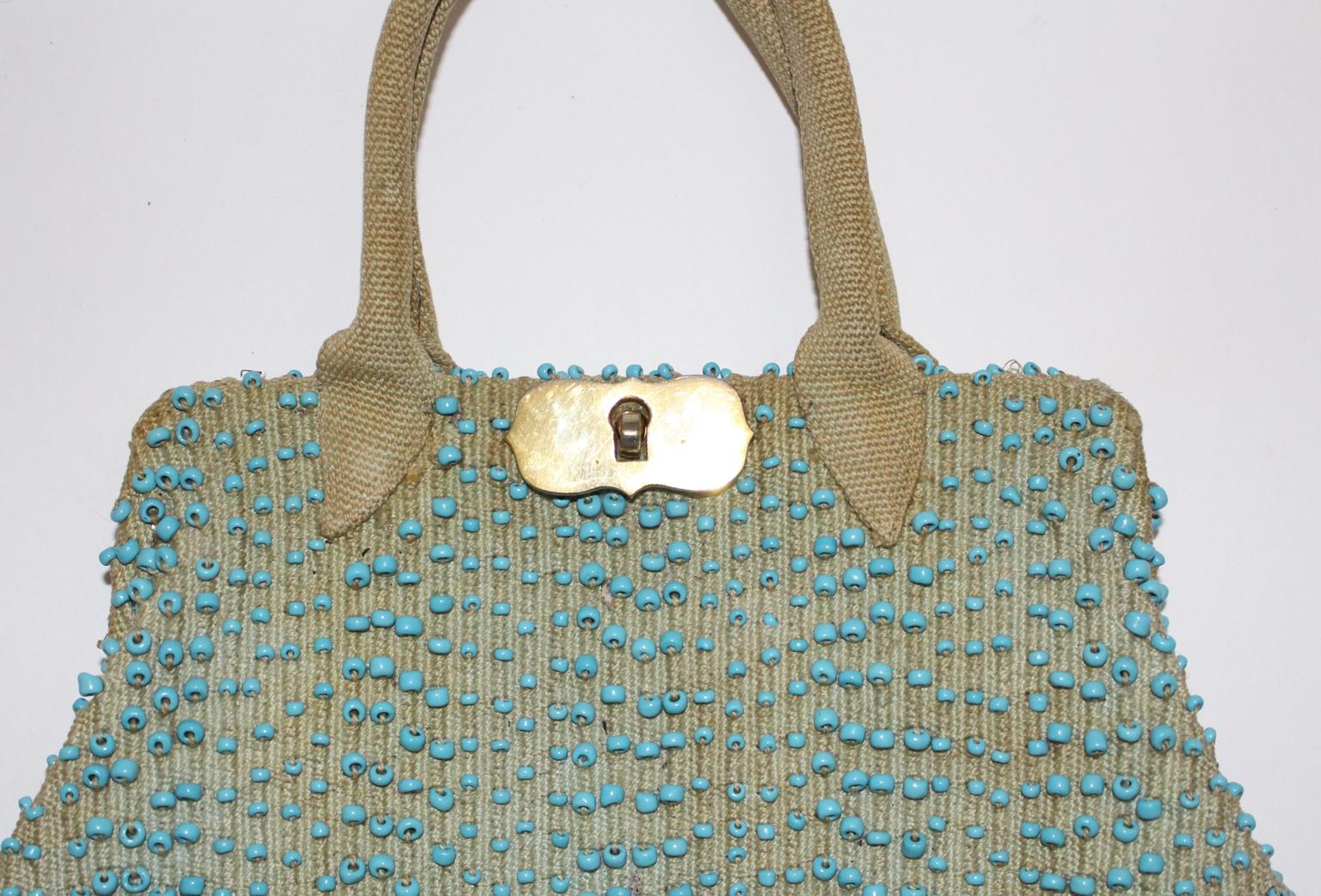 This presented rare and beautiful Vintage Handbag made of canvas and stitched with many light blue beads was designed and made in Italy c. 1950 by Roberta di Camerino.
The designer Roberta di Camerino has founded her firm in Venice c. 1945.
She