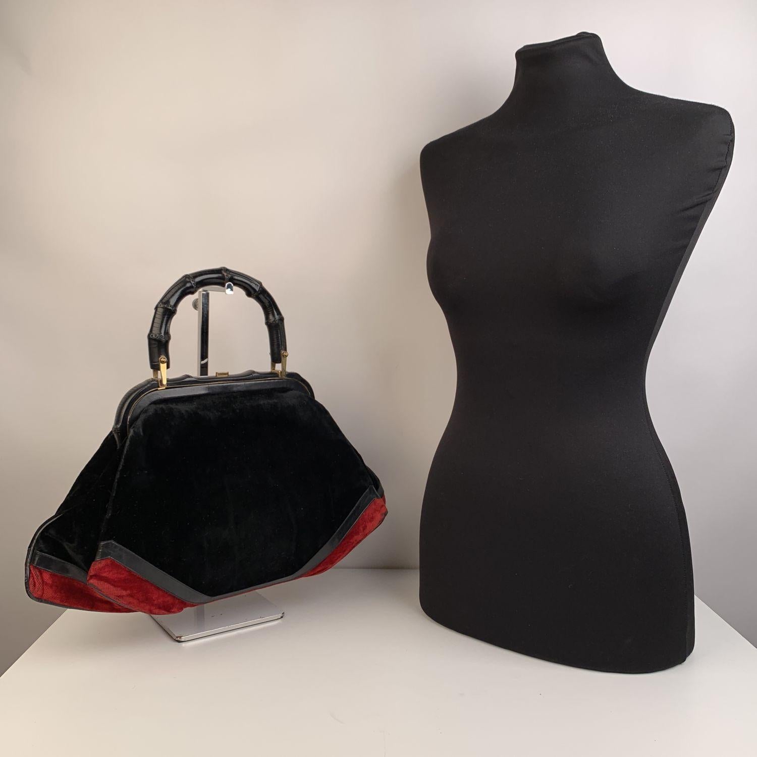 ROBERTA DI CAMERINO velvet handbag. Classic style in black and red velvet with bamboo frame and handle. Black leather trim. Gold metal hardware. It features an upper push lock closure. Leather lining. 4 side open pockets inside. 'Made in Italy by