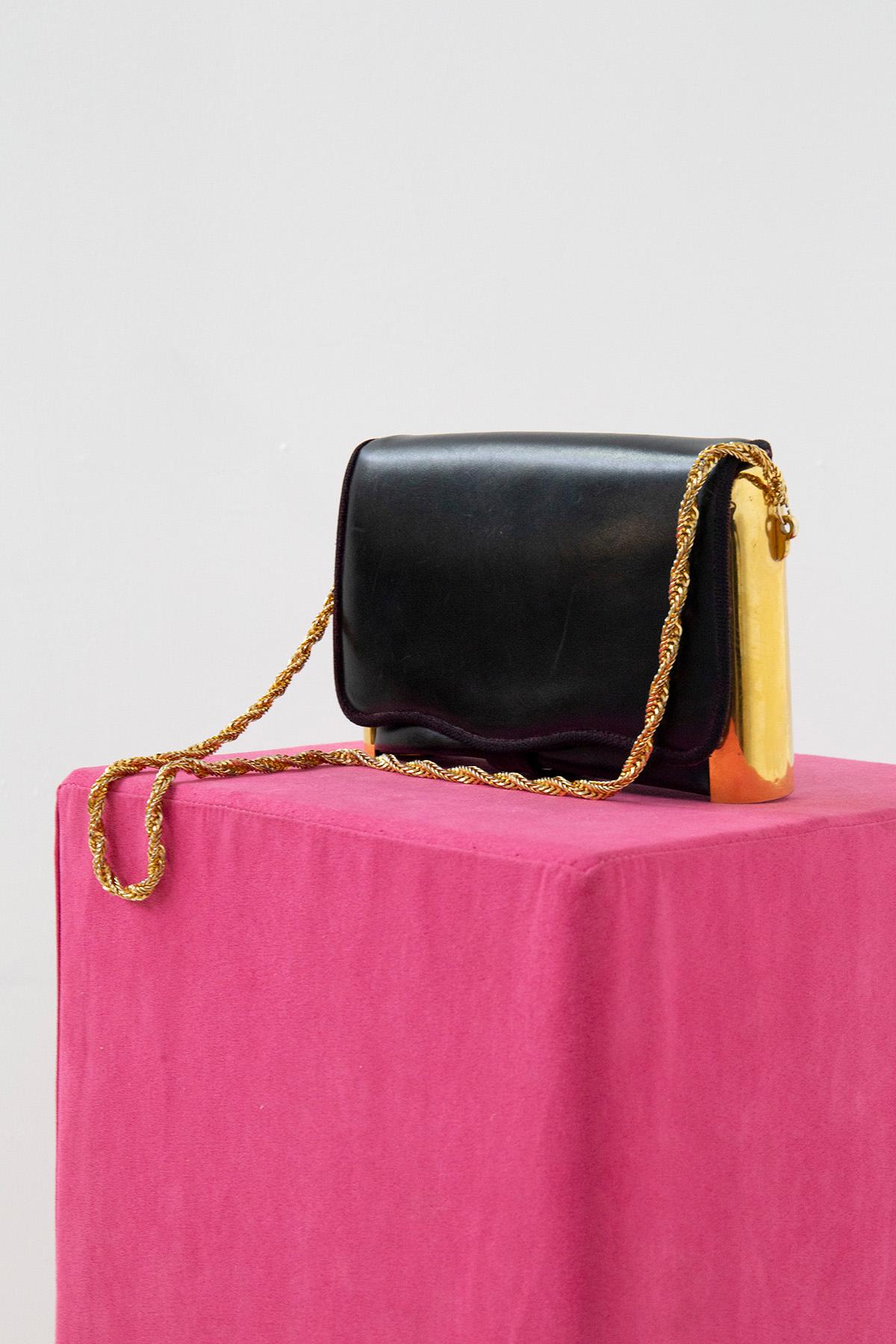 Elegante und seltene Umhängetasche von Roberta di Camerino aus den 1980er Jahren. Die Handtasche besteht aus einer vergoldeten Metallkette mit gewebtem Muster. Die Handtasche ist aus schwarzem Leder gefertigt und hat einen vergoldeten Metallrahmen,