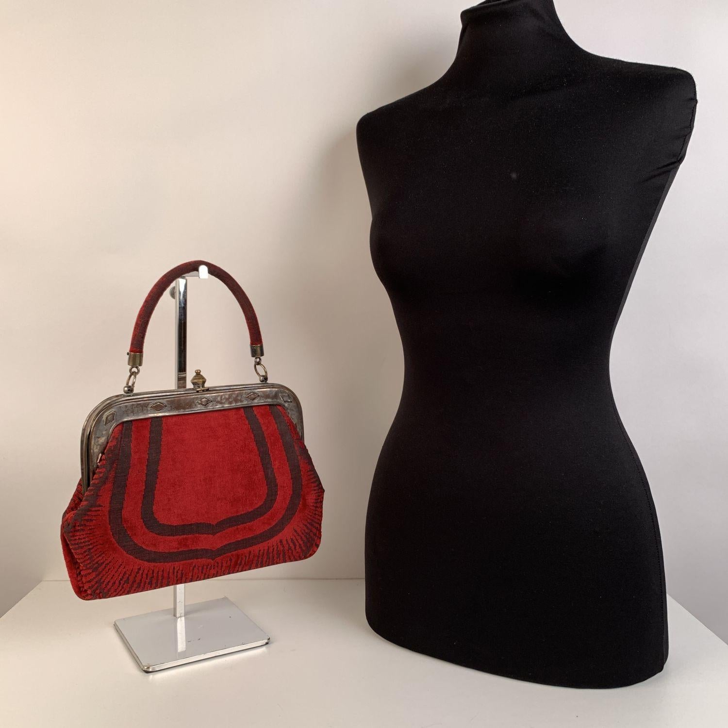 ROBERTA DI CAMERINO velvet handbag. Classic style in red cut out velvet. Metal frame. It features a leather top handle and a clasp closure on top. .Leather lining. 2 side open pockets and 1 side zip pocket inside. 