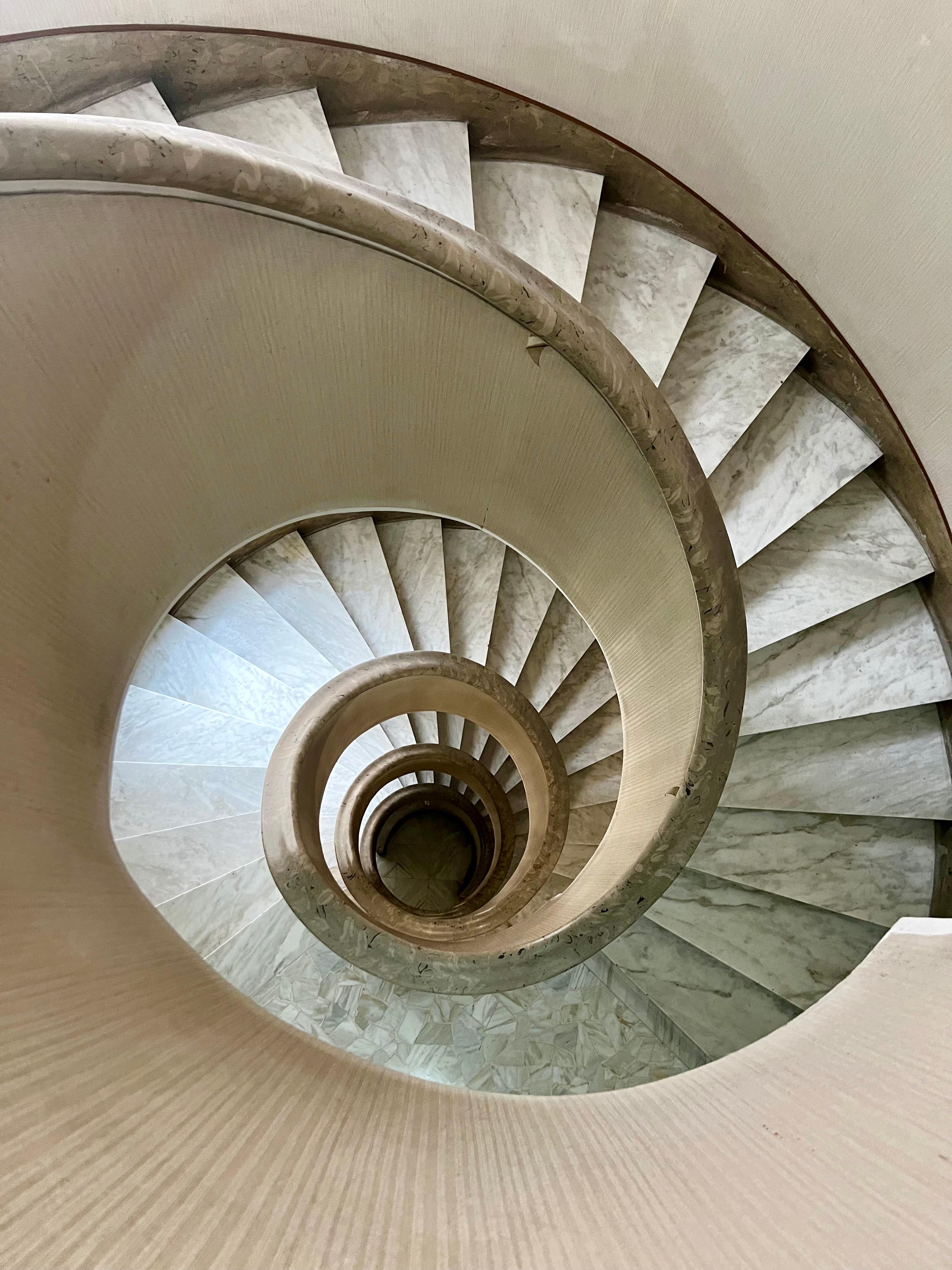 For a contemporary color photograph of a spiral staircase in Rome Roberta Fineberg captures the symmetrical cylindrical abstract quality of a building stairwell n the Eternal City. For her Cities series, RF travels often to Europe and Rome is at the