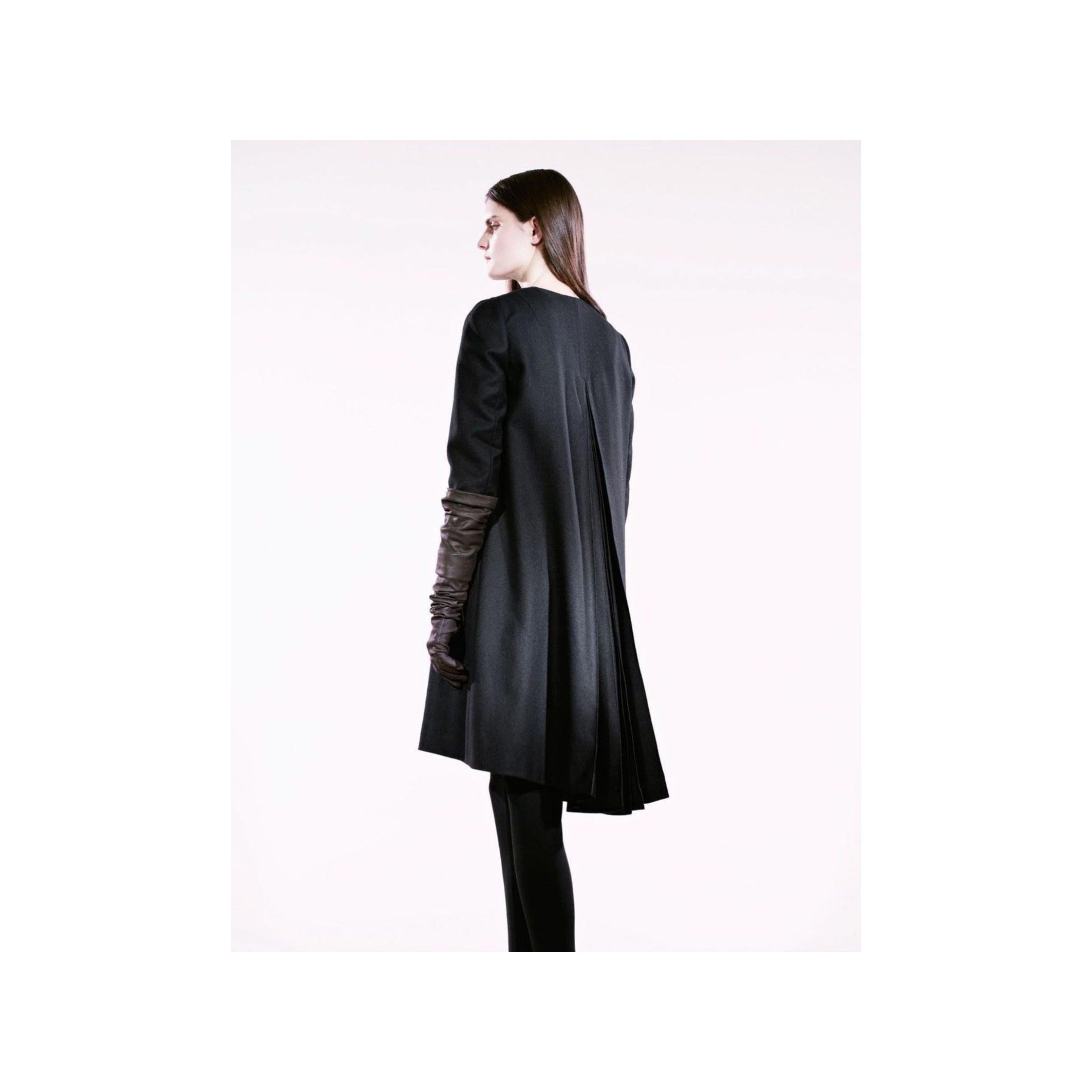 Questo cappotto di Roberta Furlanetto, foderato in seta, è realizzato in 100% lana e presenta un collo rotondo e una chiusura frontale con bottoni a pressione. L'accento plissettato sul retro aggiunge un tocco unico. Disegnato da un ex membro