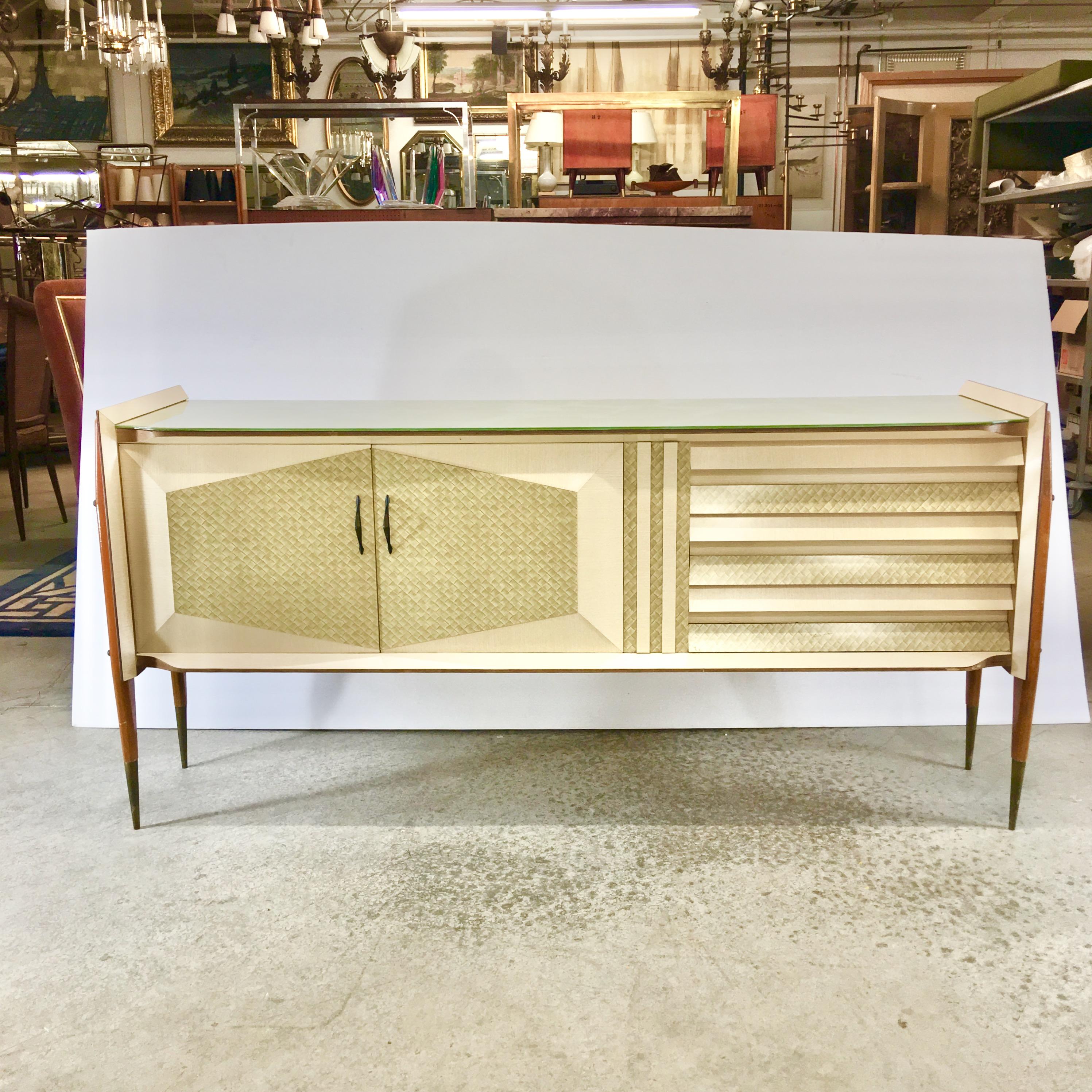 Incredible unicorn! Rare 1950s Italian sideboard attributed to Roberto Aloi.
Floating case suspended by four angles exoskeletal tapering wood legs with solid brass standoffs, acorn nuts and tapered sabots.
Faceted paneled door and drawer fronts.