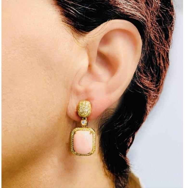 Gorgeous dangle earrings by Roberto Casarin.
Features pink coral prong set cabochons in 18k yellow gold with diamond accents.
Earrings are in good condition. Show few signs of aging or wear.

Total Diamond Weight: 1.75 carat.
Drop Length: 31