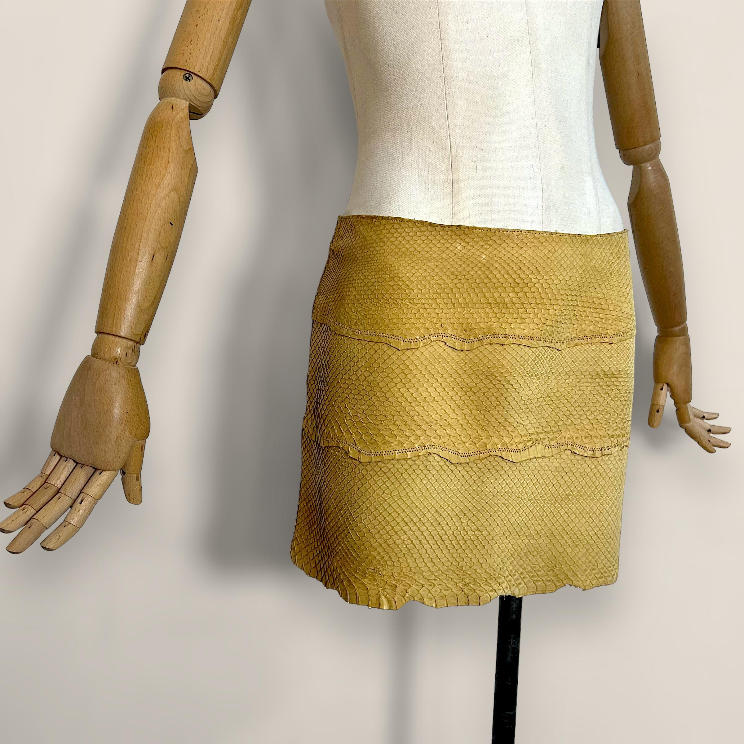 This Roberto Cavalli mini skirt, crafted from 100% leather in a vibrant yellow creme hue, features an exotic snakeskin texture. It is designed with a convenient side zipper closure. This piece is a medium size and belongs to the Spring-Summer 1999