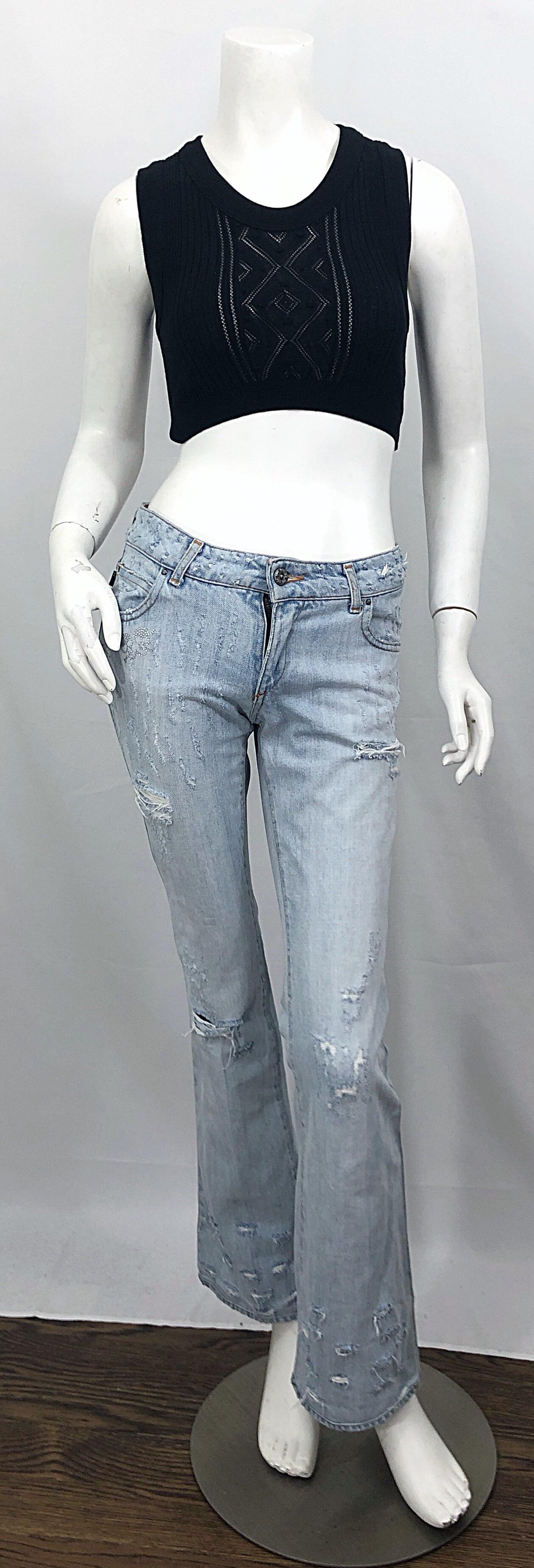 Awesome early 2000s ROBERTO CAVALLI light stonewashed distressed rhinestone skulls low rise boot cut jeans! Features distressed denim, wih two rhinestone encrusted skulls under the front right pocket. Button closure at center waistband with zipper
