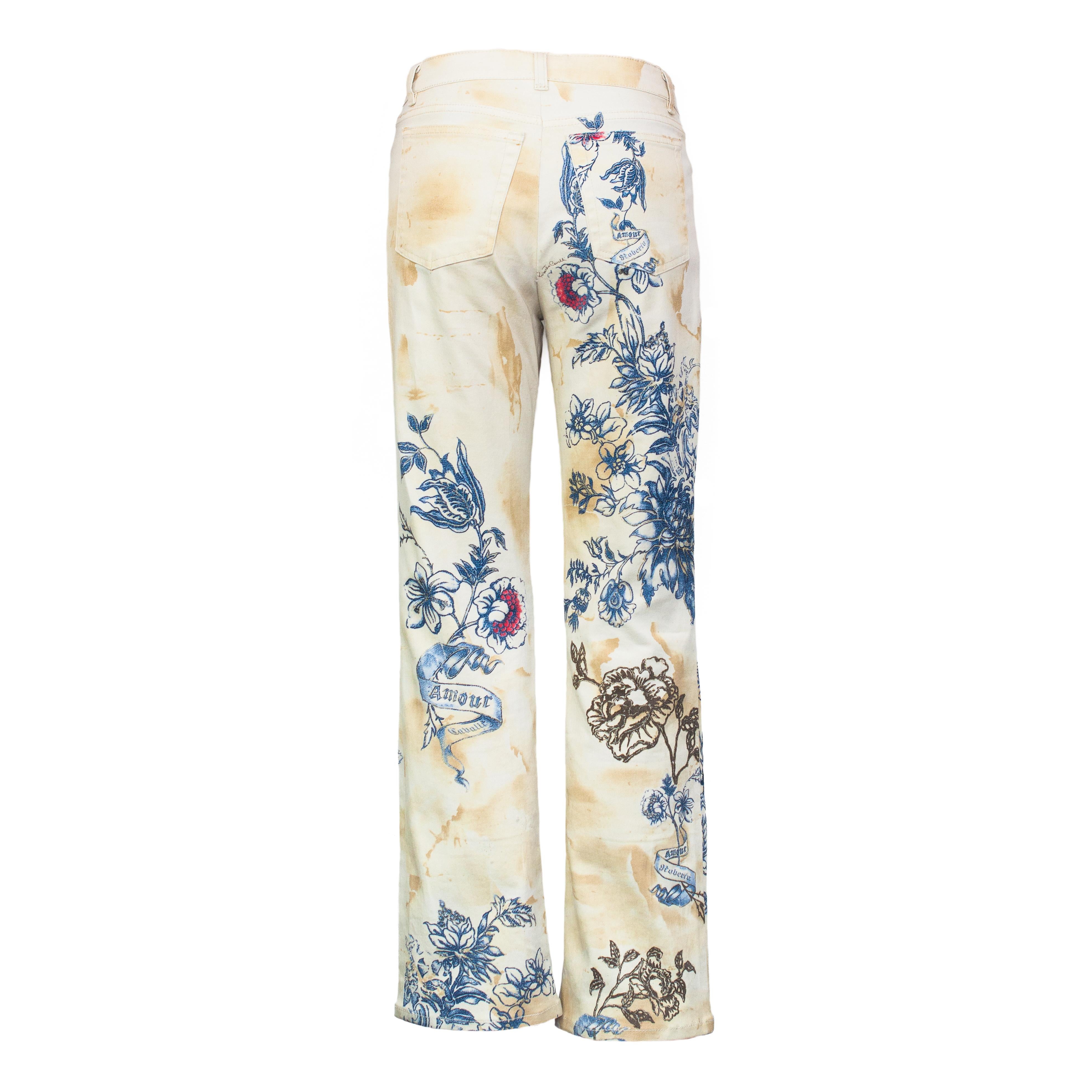 Ruder Than The Rest presents: Spring-Summer 2003 Roberto Cavalli tattoo print trousers.

Cream airbrush effect with printed glitter tattoo designs.

Features a tiger, rose, flowers and the iconic amore loveheart design.

Stretchy skinny jeans