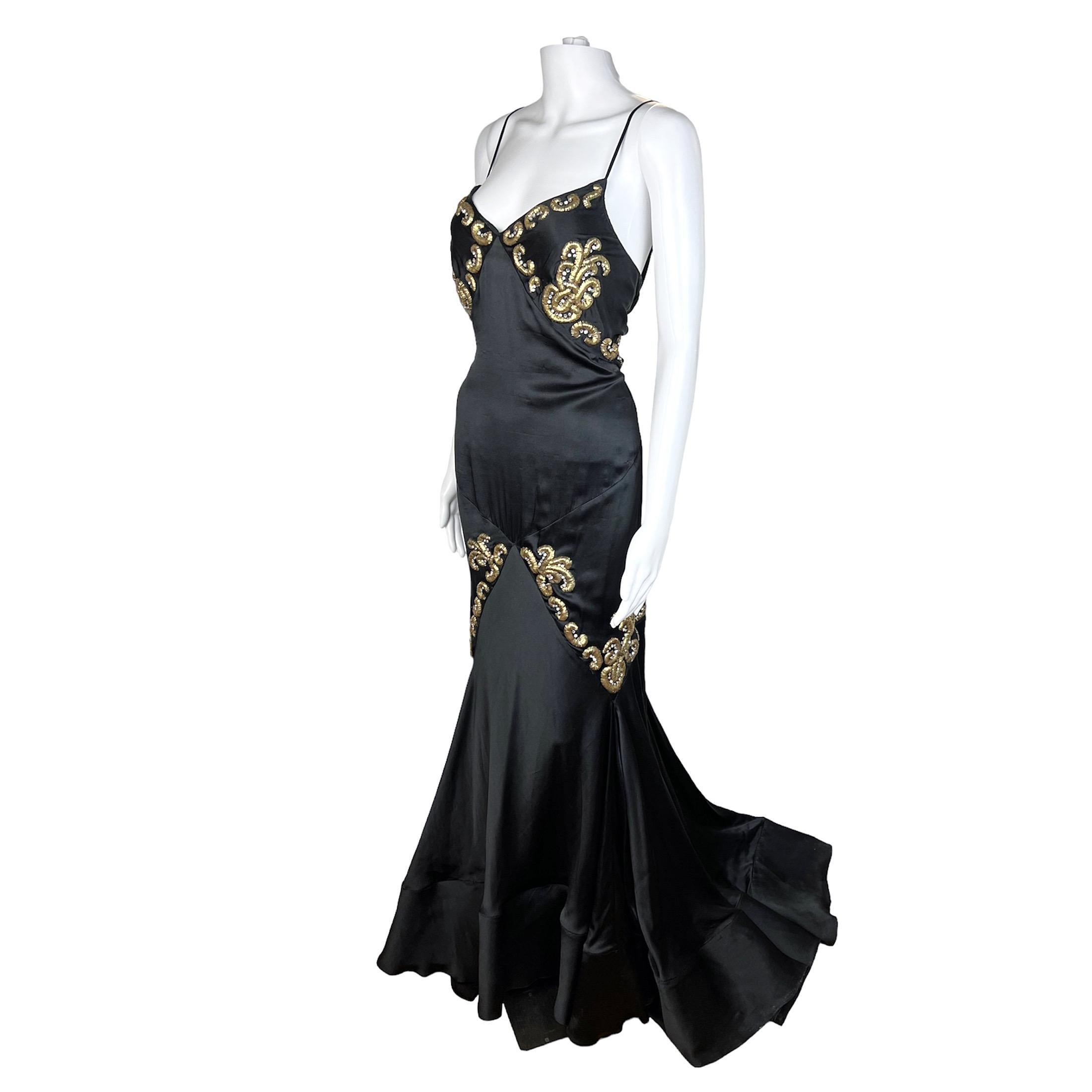 Incredible Roberto Cavalli black gown with a train and metal and crystals embellishment on front and back of bodice and silhouette from 2004. This gown is a show stopper. The hemline is lined with tulle panels giving the dress a very dramatic effect