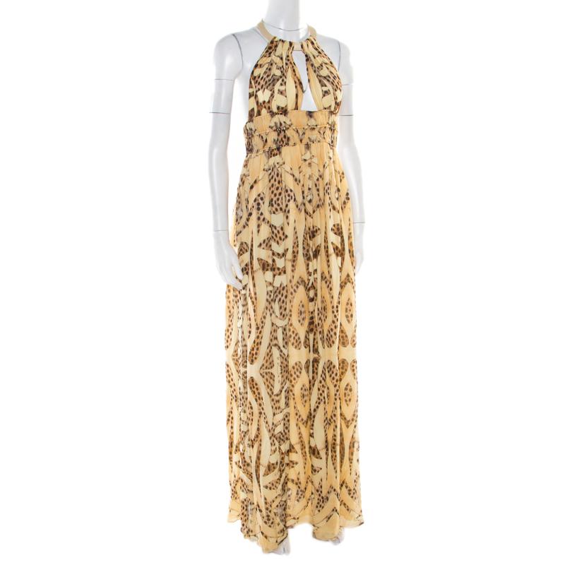 Roberto Cavalli is synonymous with animal prints and it yet again impresses us with this lovely dress! The beige creation is made of 100% silk and features a pleated silhouette. It flaunts an artistically designed plunging neckline and a cutout back