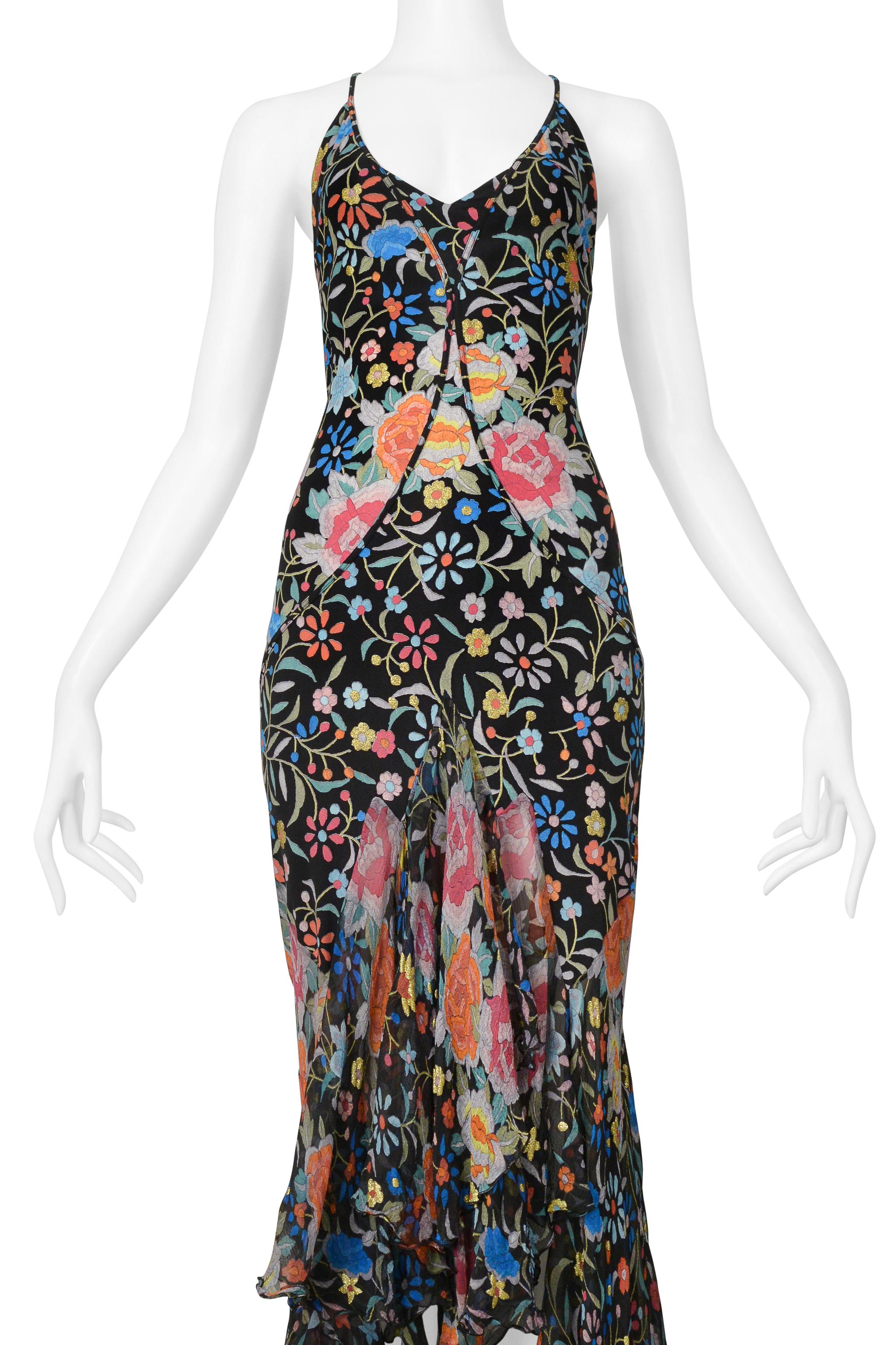 Resurrection Vintage è entusiasta di presentare un abito da sera vintage di Roberto Cavalli caratterizzato da una stampa floreale multicolore con dettagli dorati, scollatura a sottoveste, contorni dal busto alla vita sul davanti, strati di volant