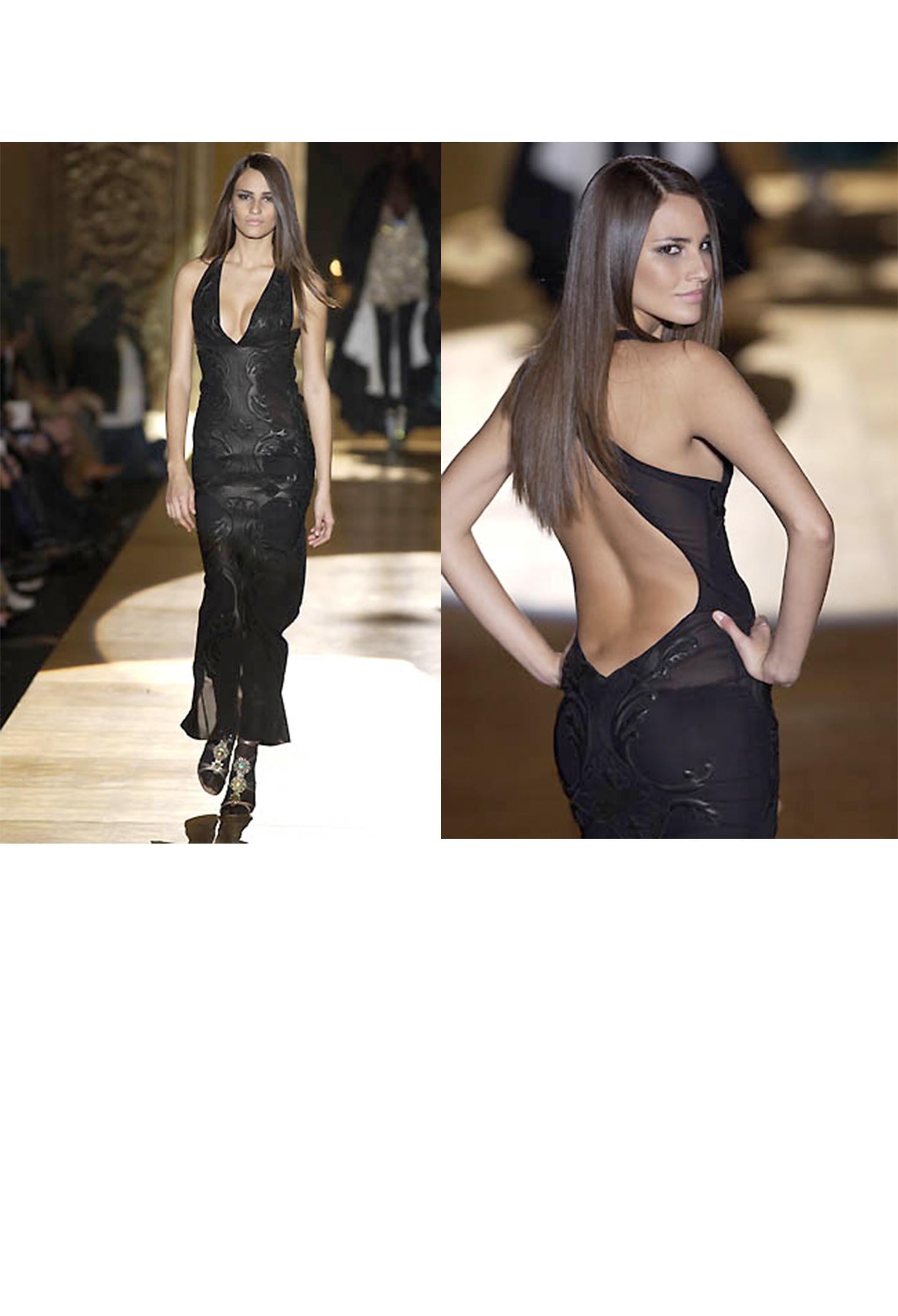 Resurrection Vintage is thrilled to introduce a stunning vintage Roberto Cavalli black mesh evening dress. It features leather appliques, a deep V neckline, an exposed back with criss-cross straps, a fitted body, a center back slit, and gown