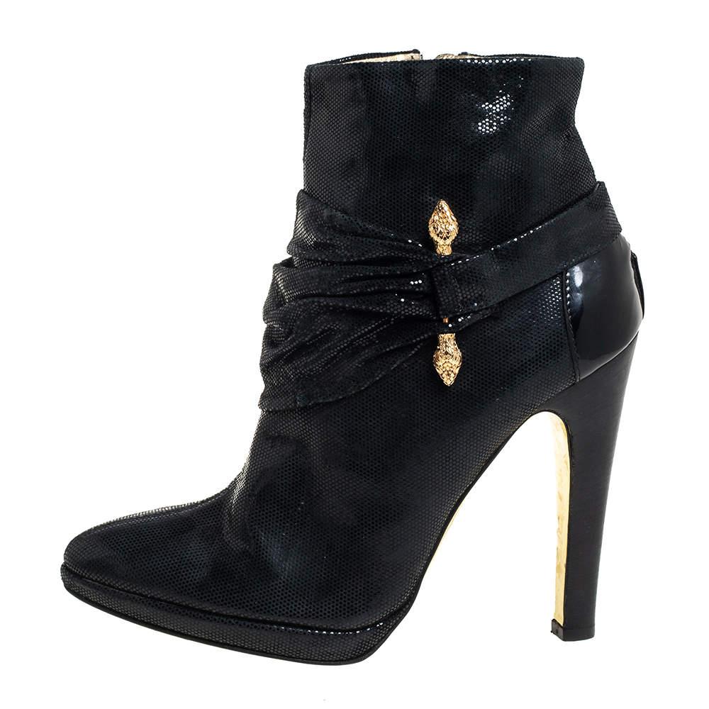 Crafted from nubuck in a black shade  these Roberto Cavalli boots are simply gorgeous They are designed into an almond toe silhouette and feature gold tone hardware and pleated detail around the vamps.
