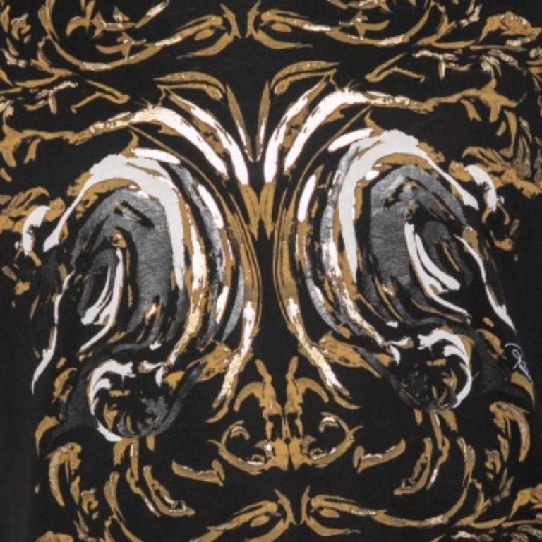 Esta camiseta Roberto Cavalli eleva tu cociente de estilo un par de peldaños. Está confeccionado en algodón de color negro y luce la firma de la marca estampada en la parte delantera. Tiene un corte extragrande, un dobladillo recto y mangas cortas.
