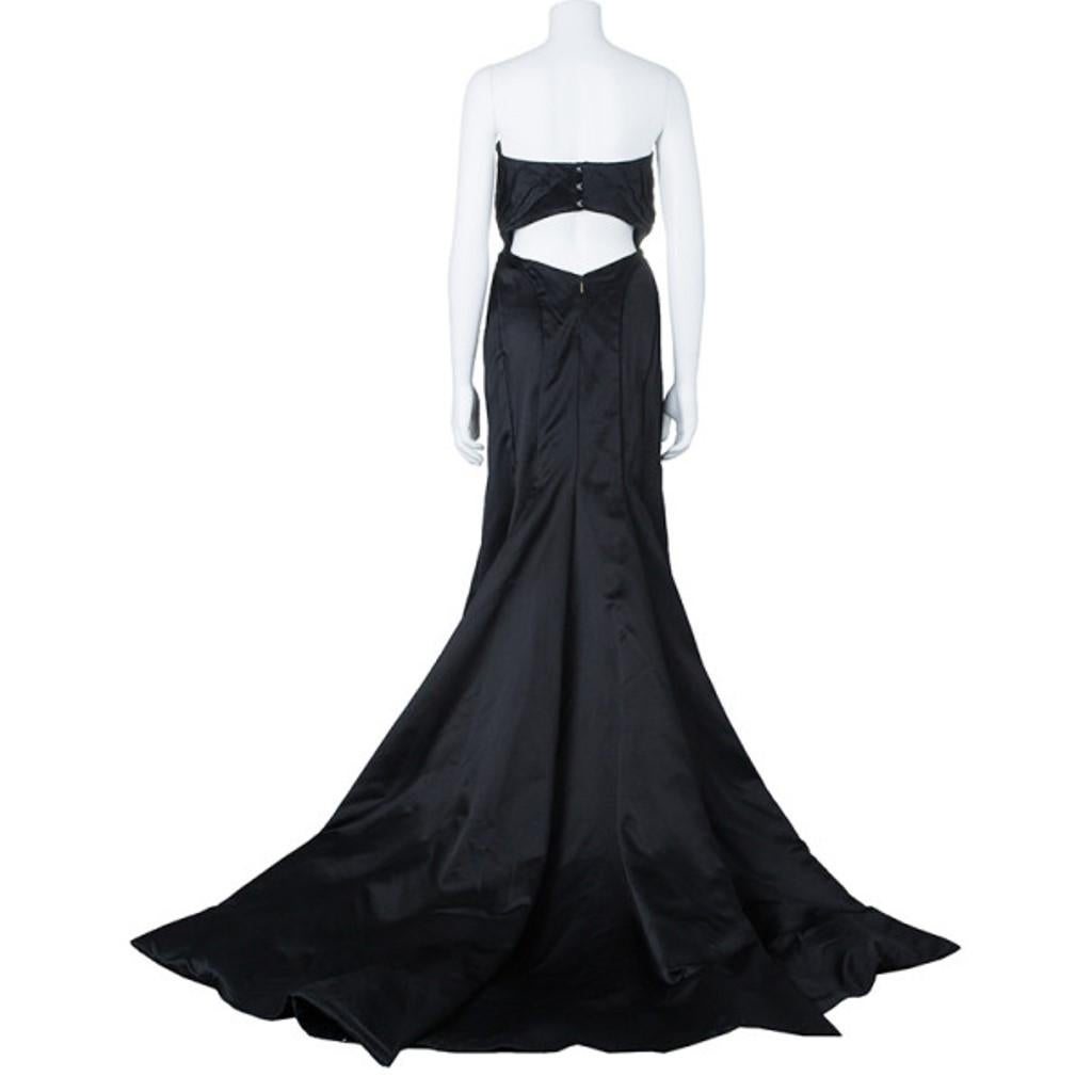 Be the bell of the ball in this stunning Roberto Cavalli black silk evening gown. It features a fit and flare design with pleating in the front to add exquisite detailing and a cut-out in the back. It also has a zip closure in the back along with